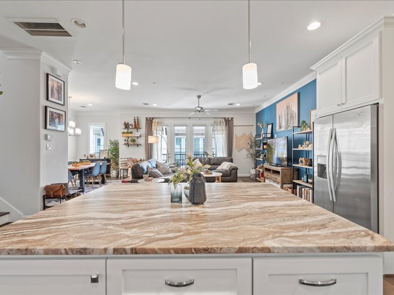 The gourmet kitchen is complete with stainless steel appliances, a large island with a breakfast bar, and elegant finishes.