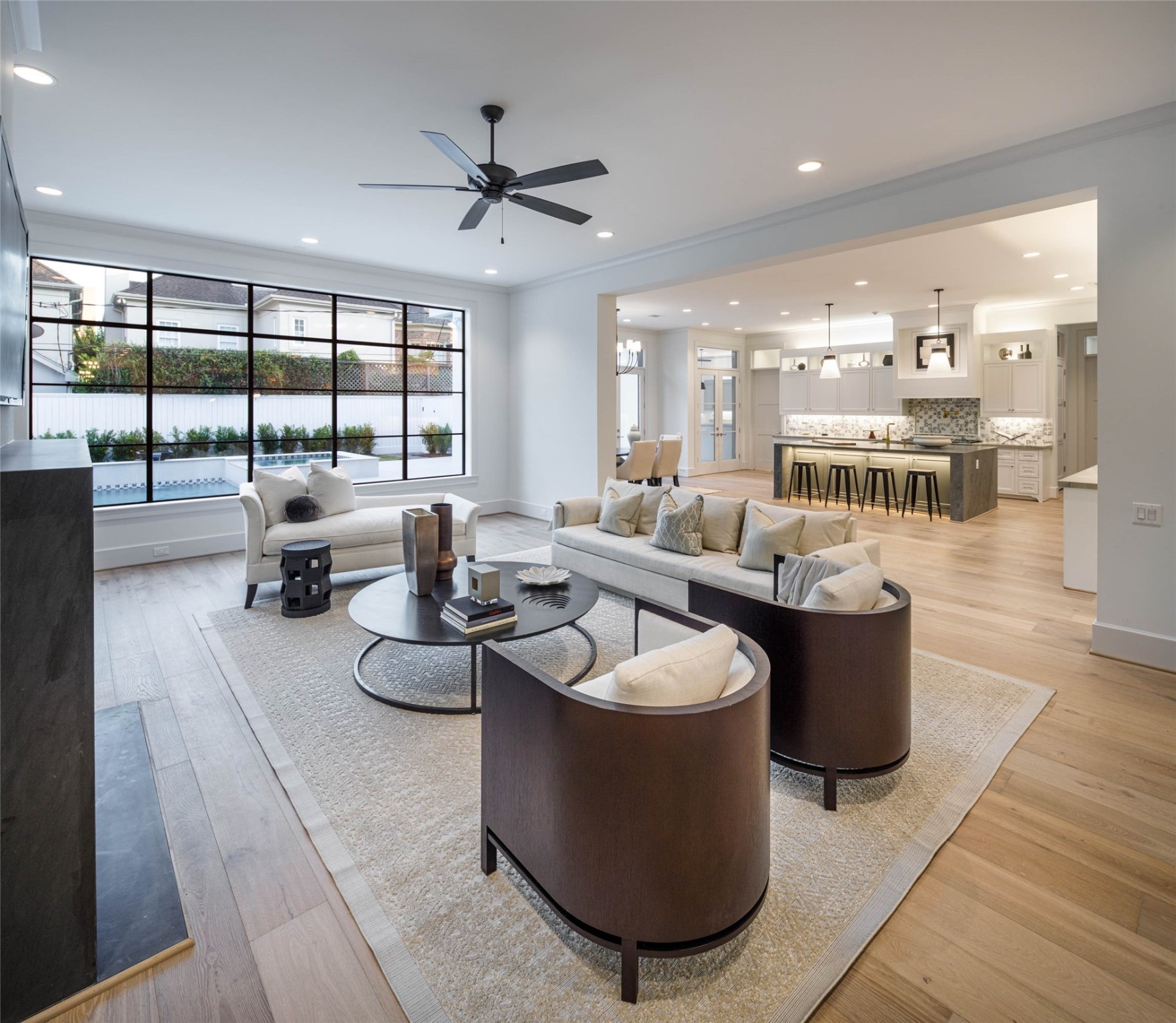 Alternate family room with engineered white Oak wood floors and a wall of windows with Southern exposure and extended views to the Pool/spa and back yard