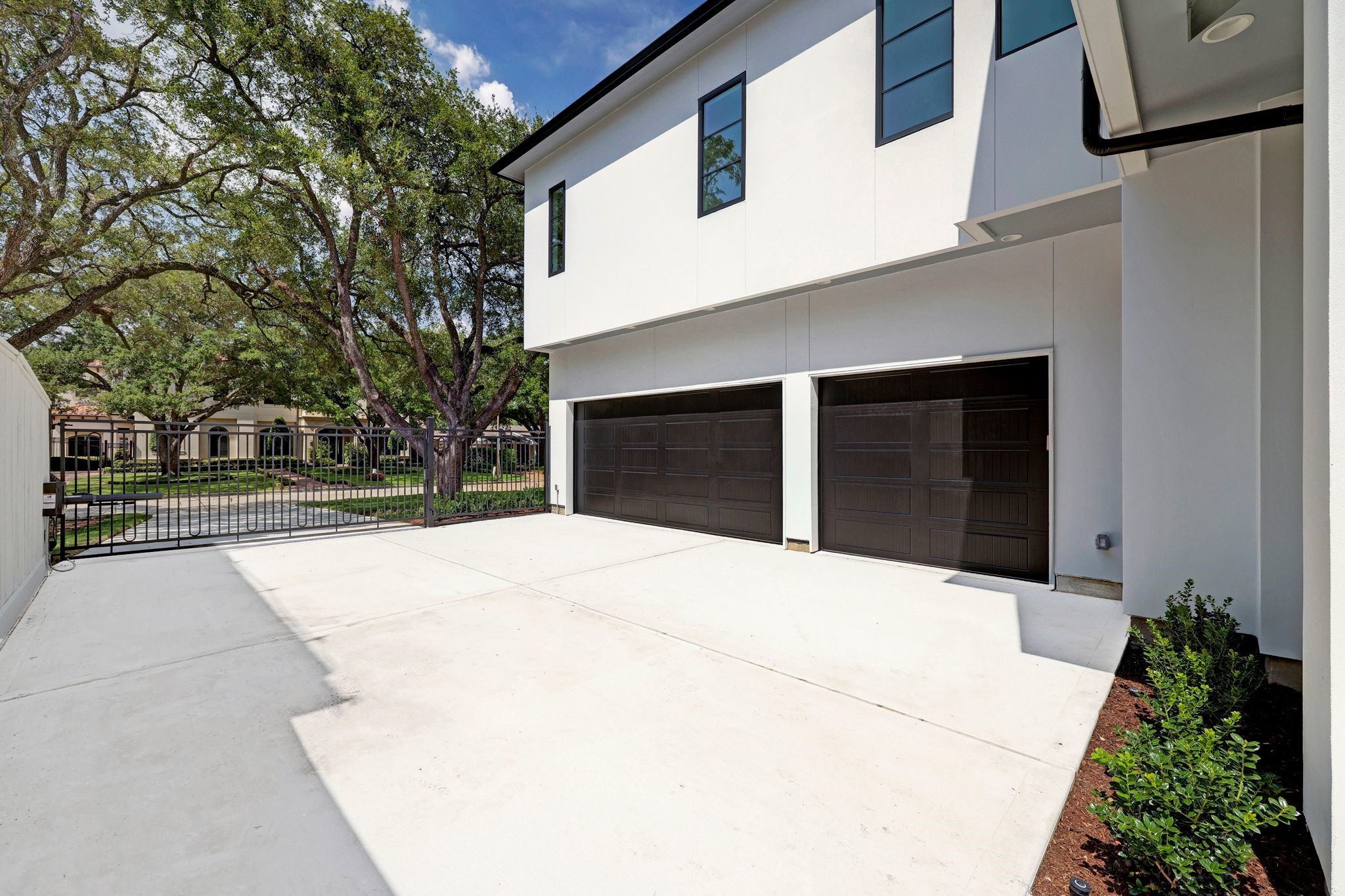 Electronic driveway gate leading to a Three car attached garage and additional parking space