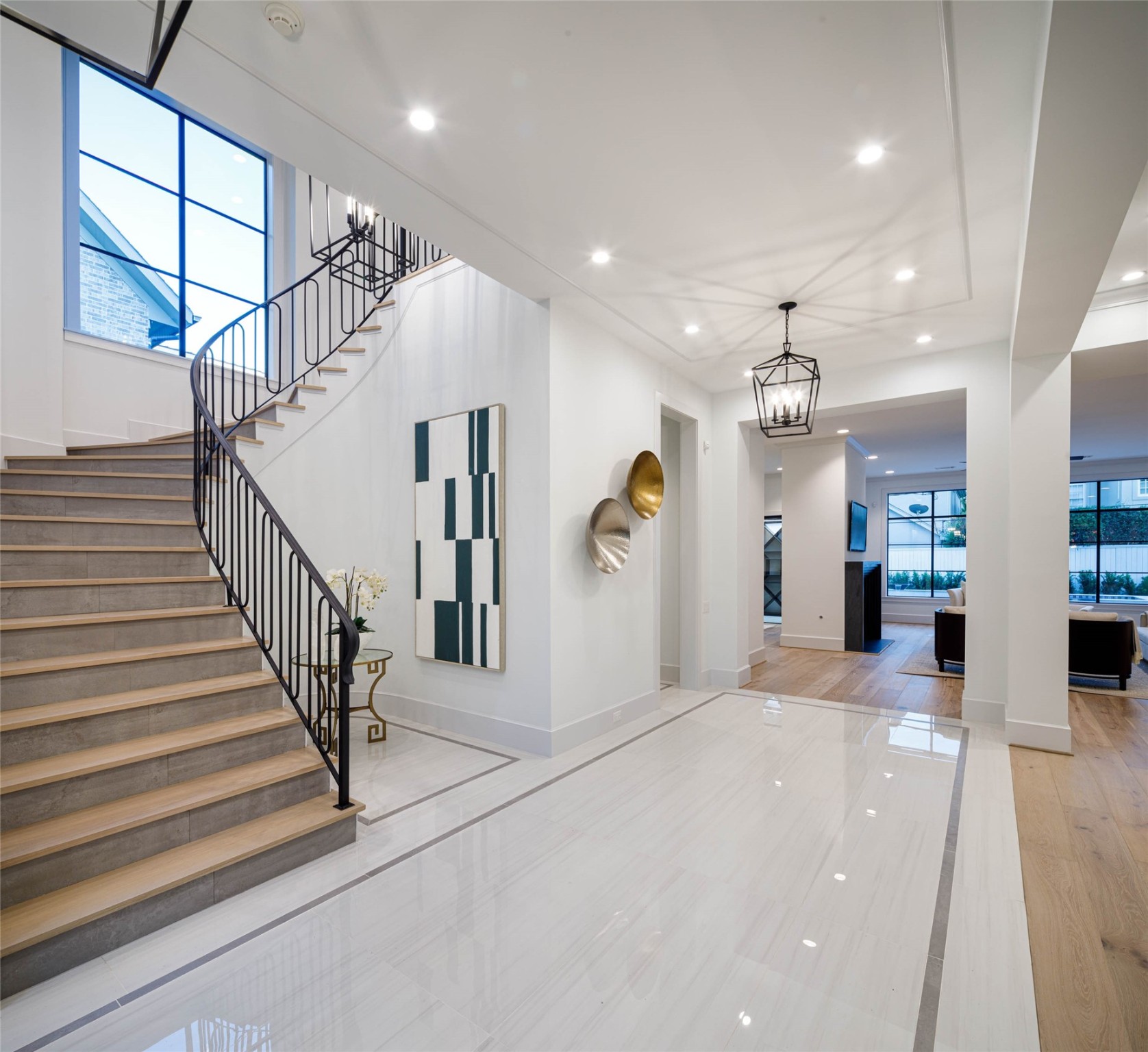 Grand entry foyer featuring beautiful Porcelain floors and two elegant designer chandelier. Opens to a private office making a stunning first impression of effortless elegance and sophisticated touches