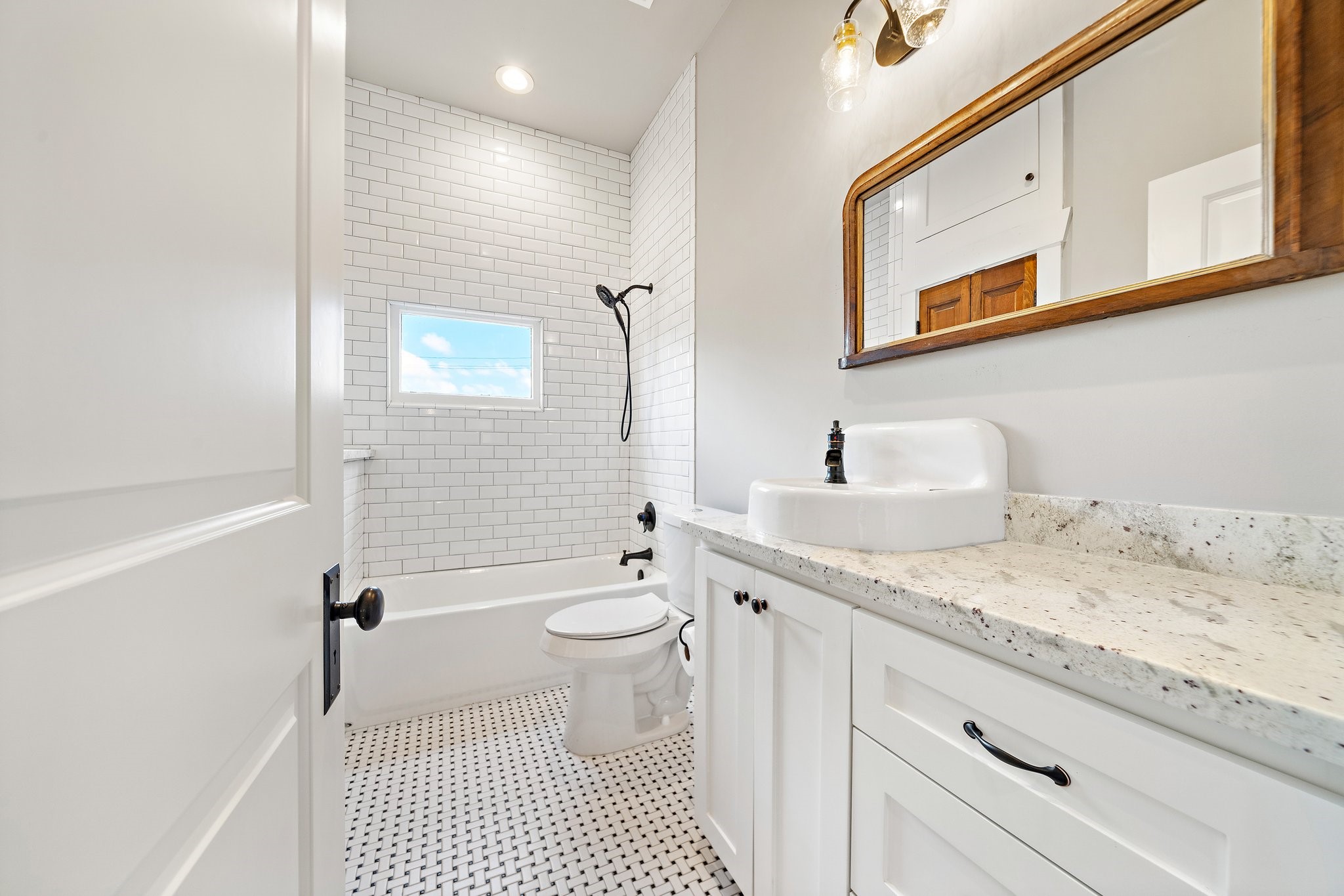 Guest bathroom - located between the 2 guest rooms, in true Craftsman style! Refinished antique sink and vintage mirror. Linen closet and custom cabinets up top! Storage is the name of the game at this house!