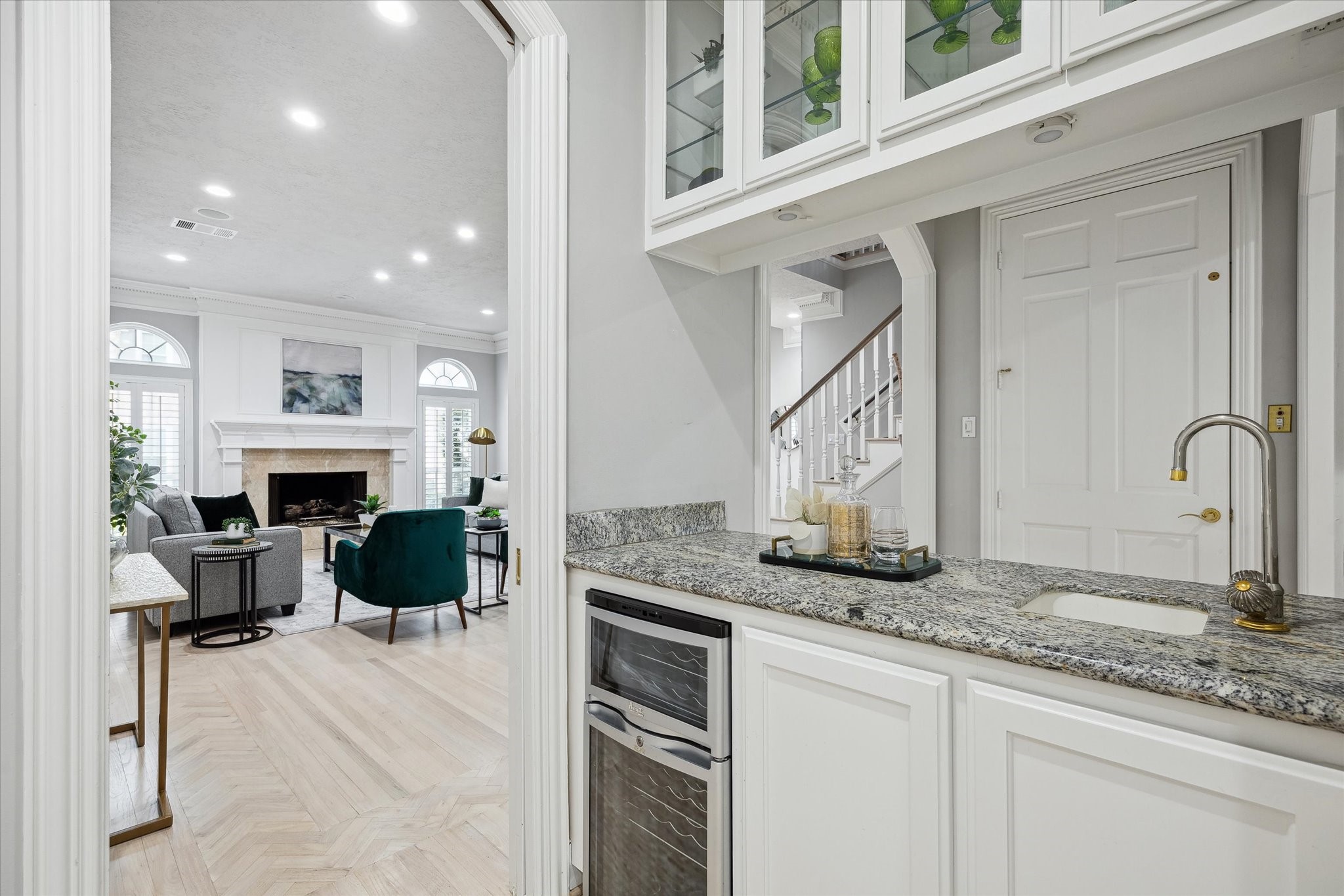 The wet bar with wine chiller has granite counters and is centrally situated off the kitchen making it convenient for servicing family and friend gatherings.  Across from the bar area is the elevator closet that serve 1st and 2nd floors.