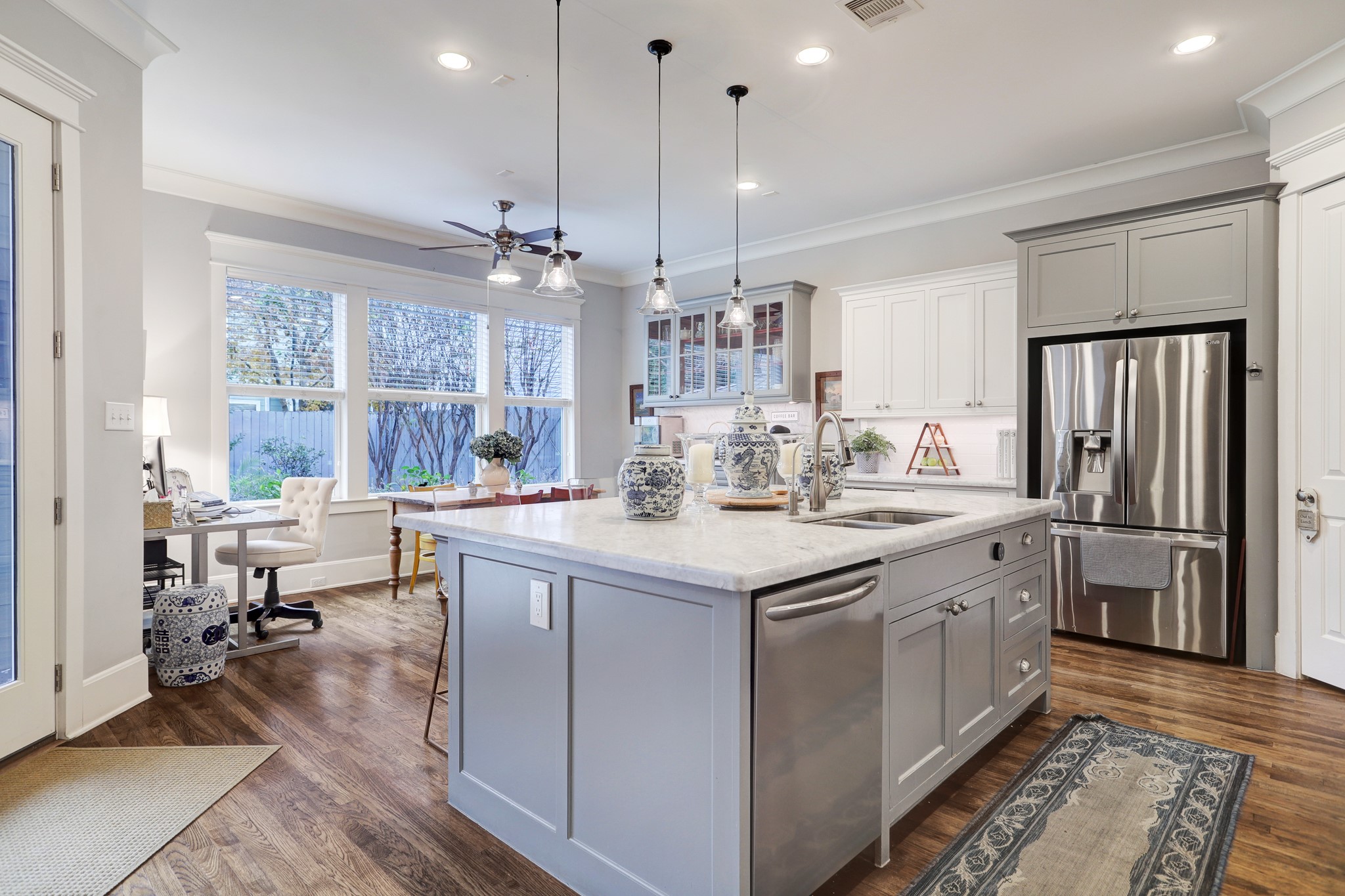 This sizable kitchen features elegant marble island and counter tops, stainless steel appliances, a walk-in pantry, built-in coffee bar, ample storage space, and plenty of room for a dining table.