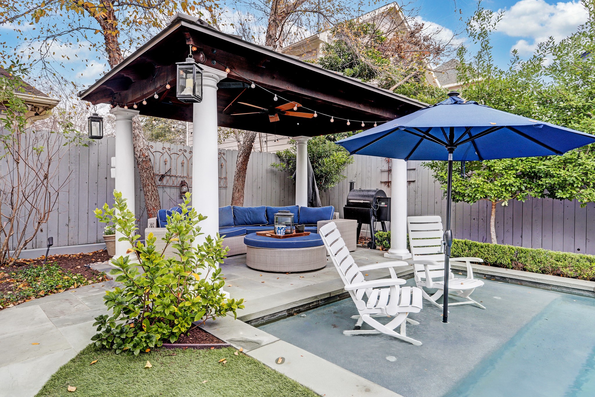 The covered outdoor pergola has plenty of space for lounging and has a drop-down tv built into the structure.