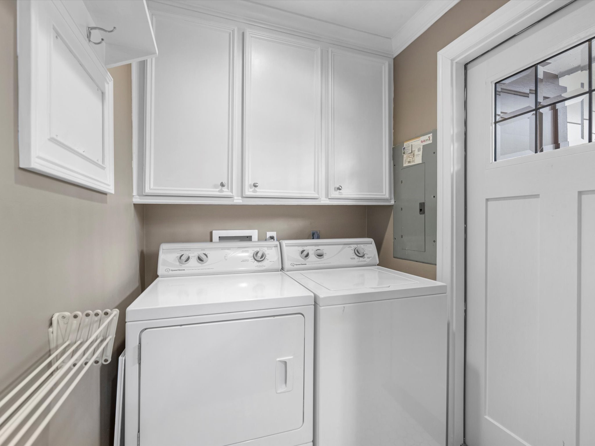 The in-house laundry room has built-in cabinets.