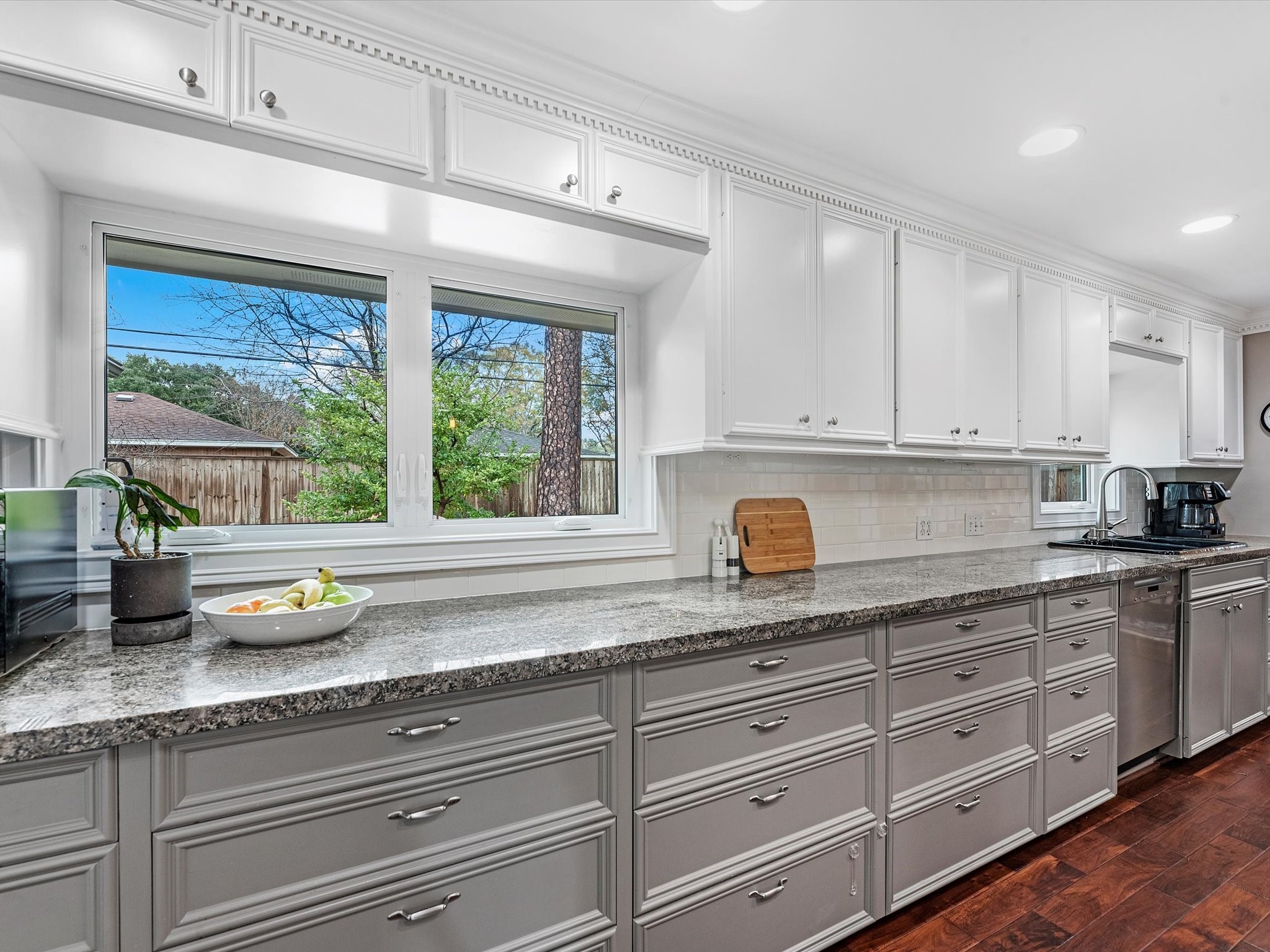 There is no shortage of cabinets and drawers here. Enjoy meal prep or dish cleanup as you gaze into your backyard through two sets of windows!