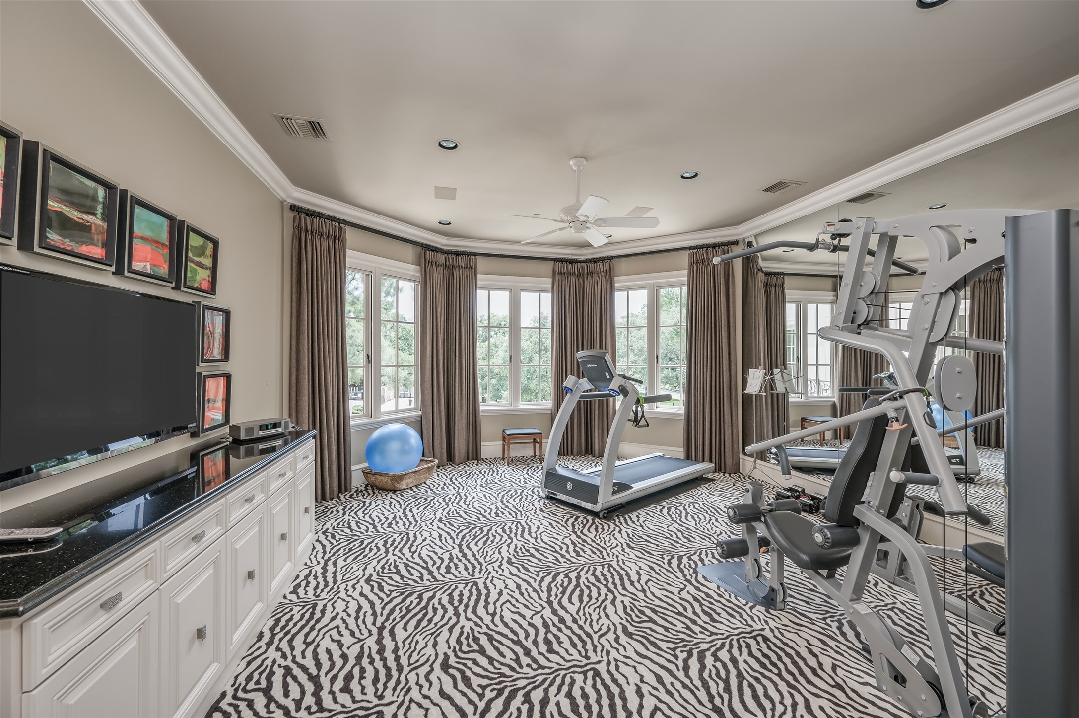 [Gym]
Black-out drapes, a media cabinet, and mirrored wall complete the gym.t