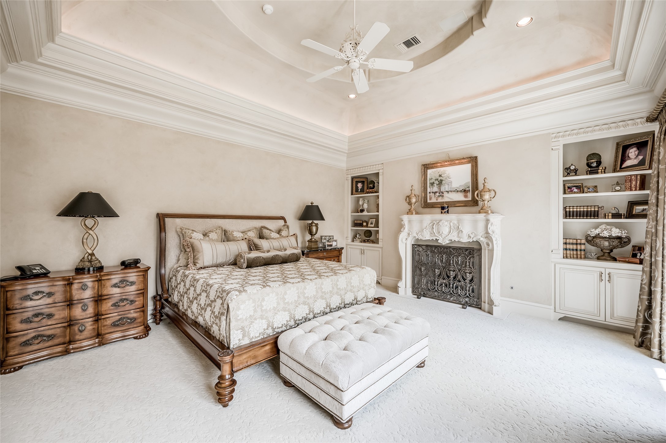 [Primary Bedroom]
Separated from the morning room by pocket doors, the serene bedroom has an elaborately carved stone fireplace.