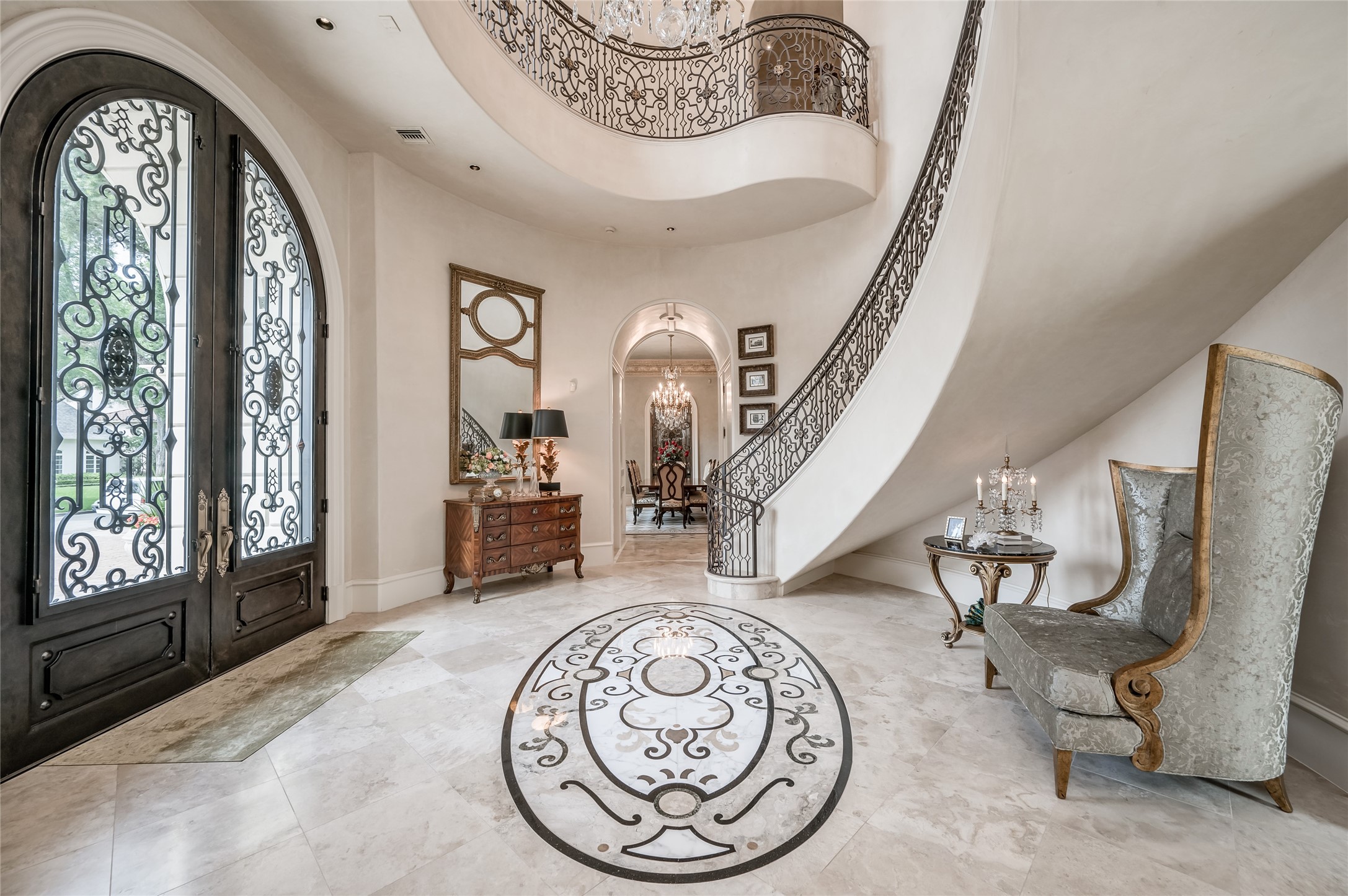 [Foyer]
Imposing iron and glass front doors open into the double-height, rotunda foyer, enhanced by a faux gilt domed ceiling and inlaid marble floor.