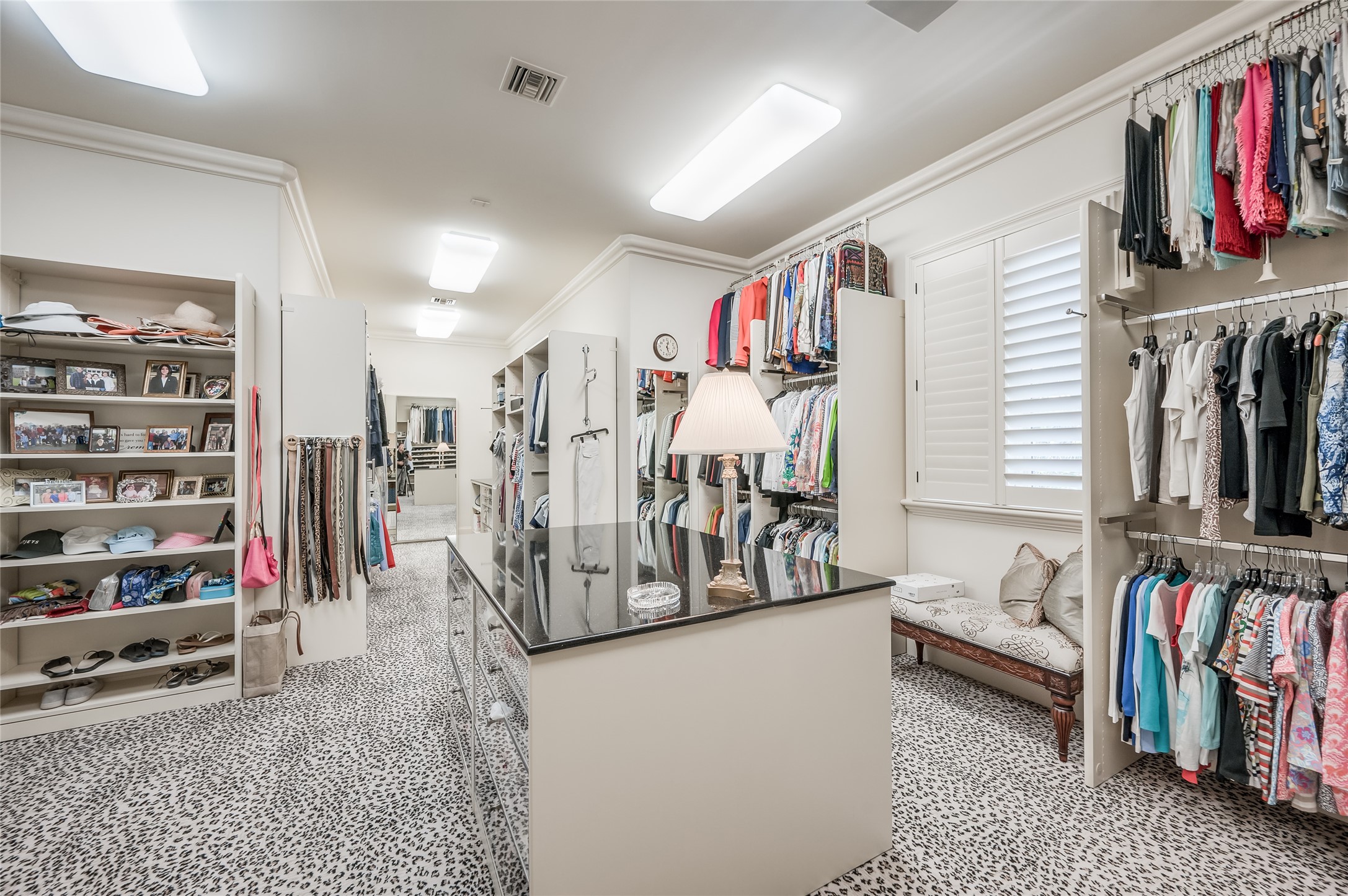 Primary Closet (1 of 2)
A pair of bespoke walk-in closets feature packing islands with drawer storage, custom mirrors, and custom-d