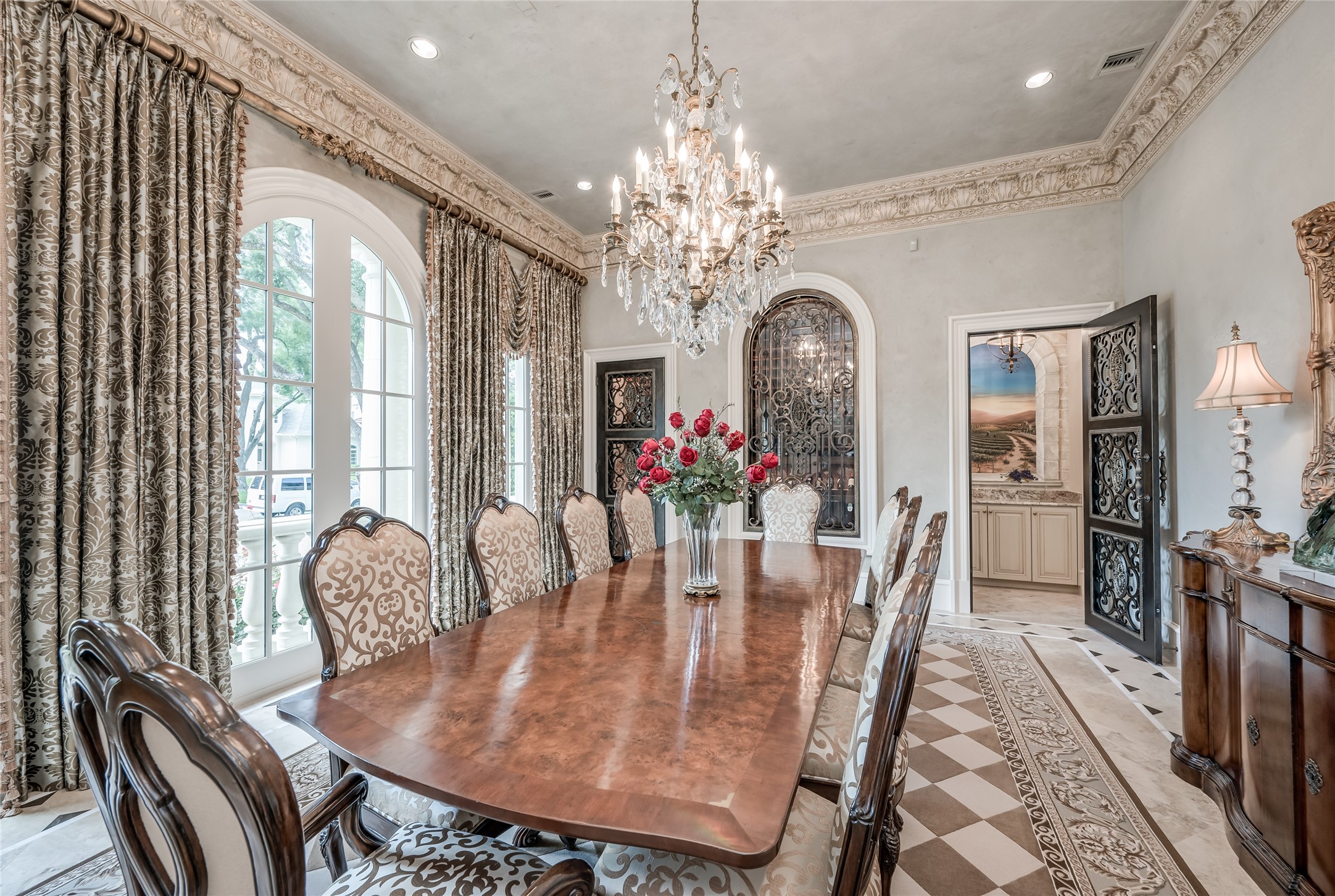 [Dining Room]
The dining room, enhanced by deep, faux gilt acanthus-leaf molding, includes a temperature-controlled wine vault with glass and bronzed-steel door and window, a brick floor, and storage for approximately 700 bottles.