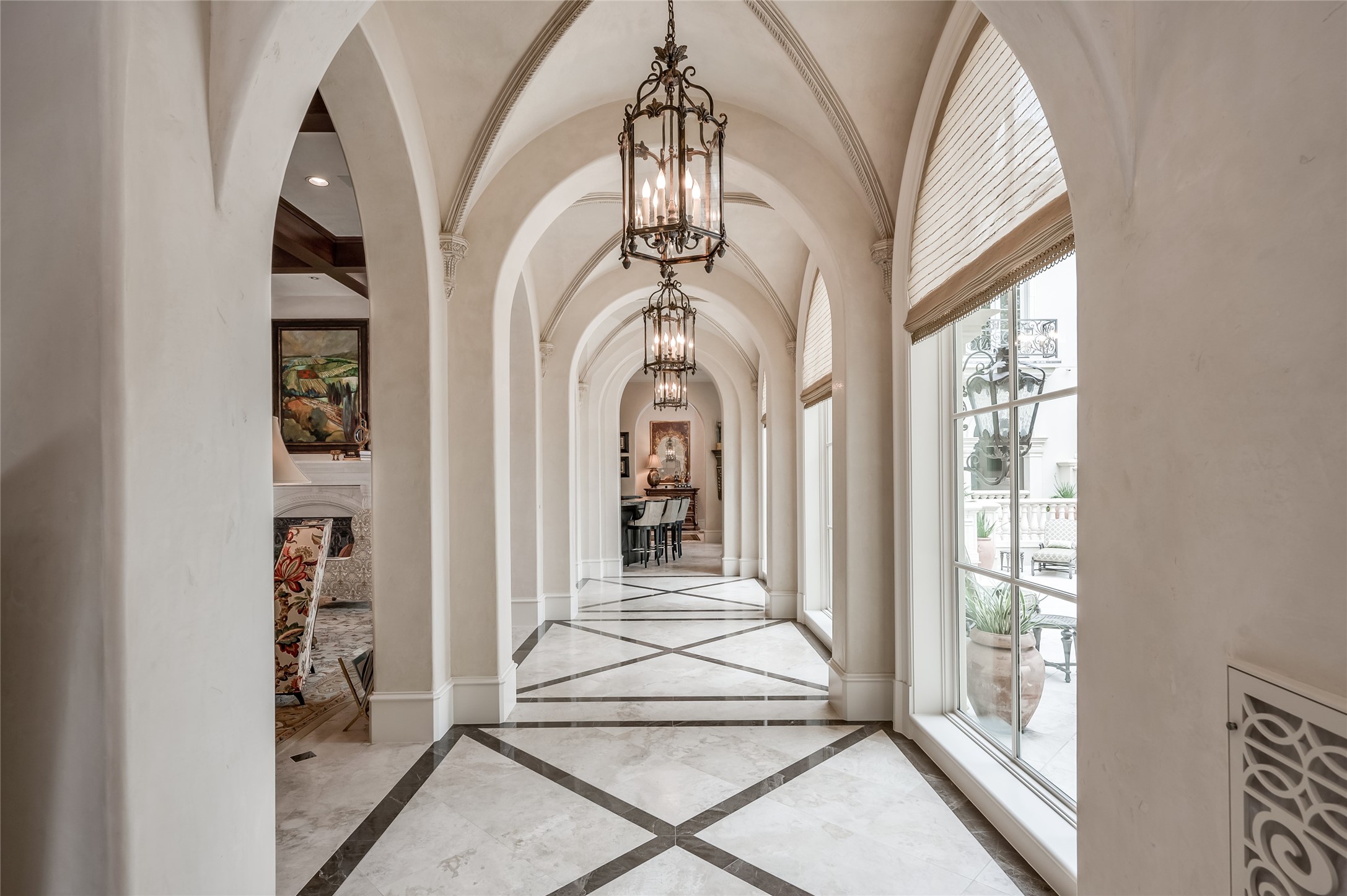 [Gallery]
A wide, groin-vaulted gallery, with an exterior wall of full-length windows that overlook the patios and pool, travels from the foyer to the palatial living room.