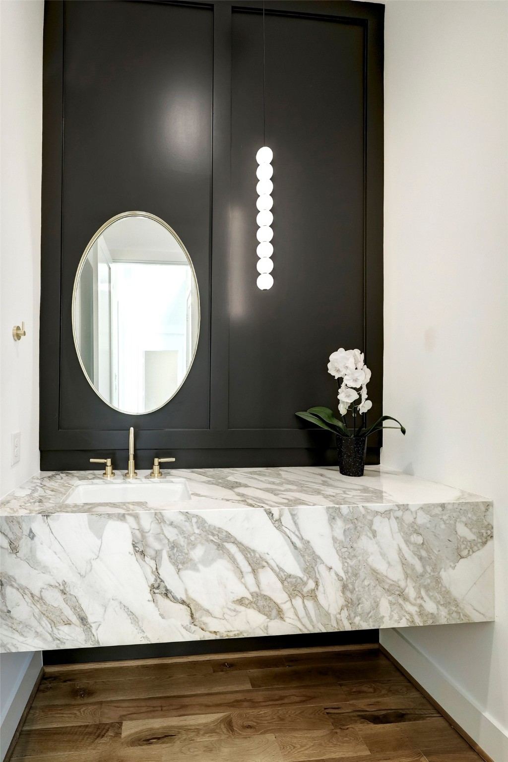 Powder room with designer natural stone slab floating vanity and finishes