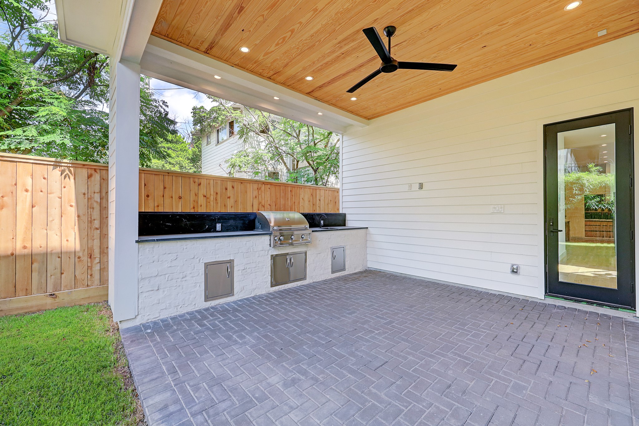 Covered outdoor kitchen with grill & pool-sized backyard with bamboo landscape for privacy