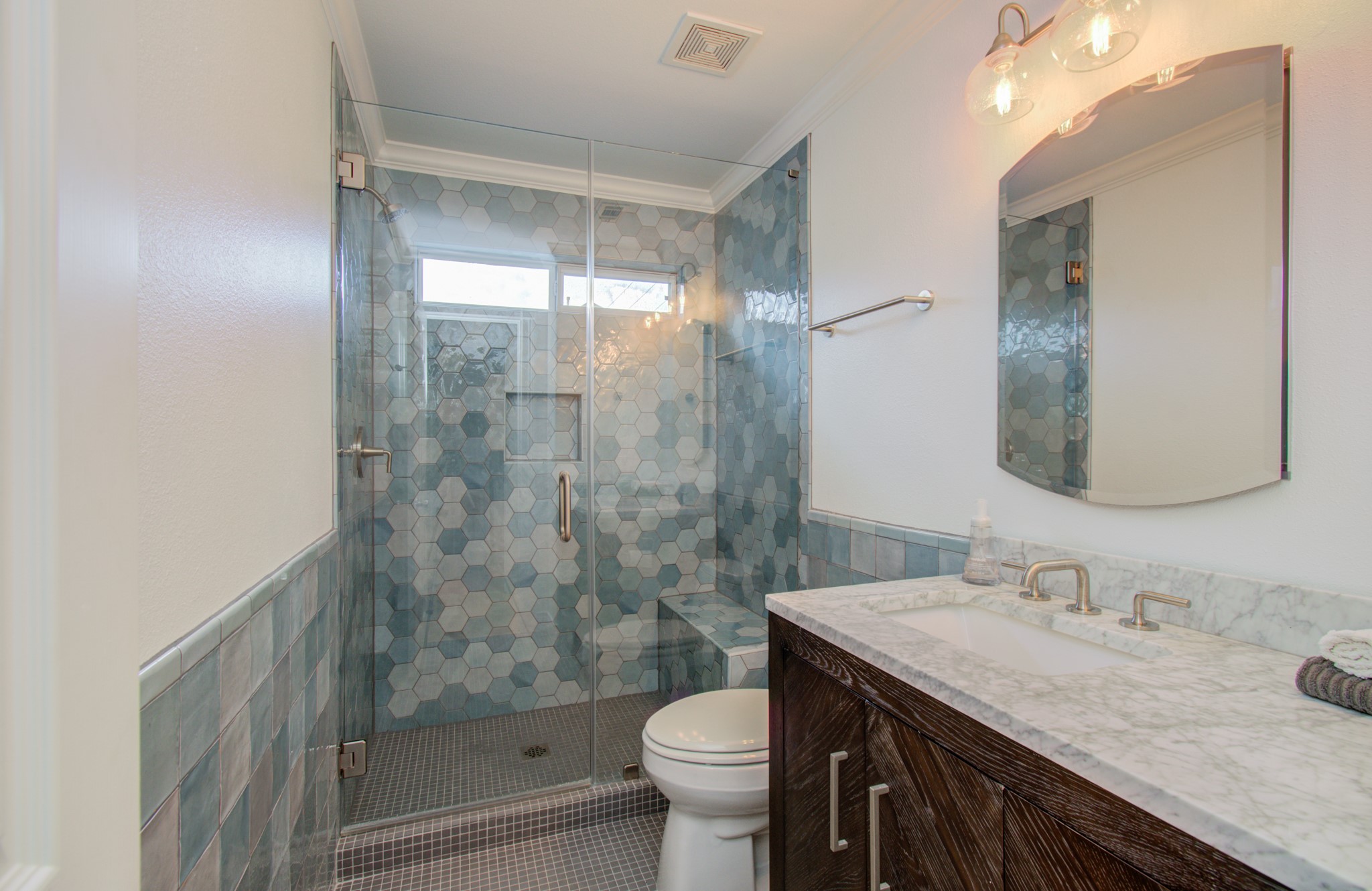 The secondary bathroom, also remodeled in 2021, is adorned with WOW Zellige tile, reflecting a contemporary and stylish update.