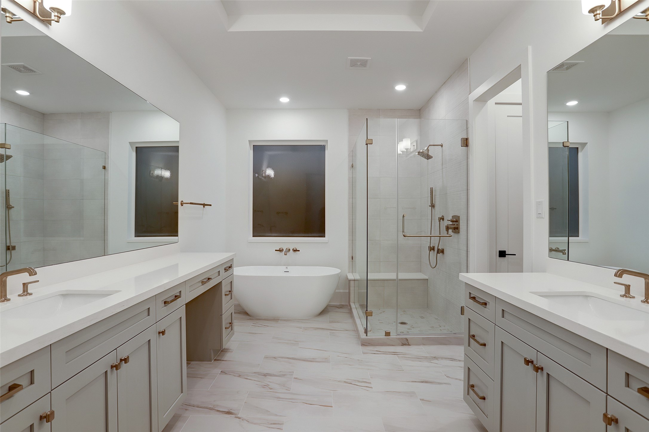 A draw dropping primary suite with his and her dedicated vanity areas, seamless glass shower and statement soaking tub.