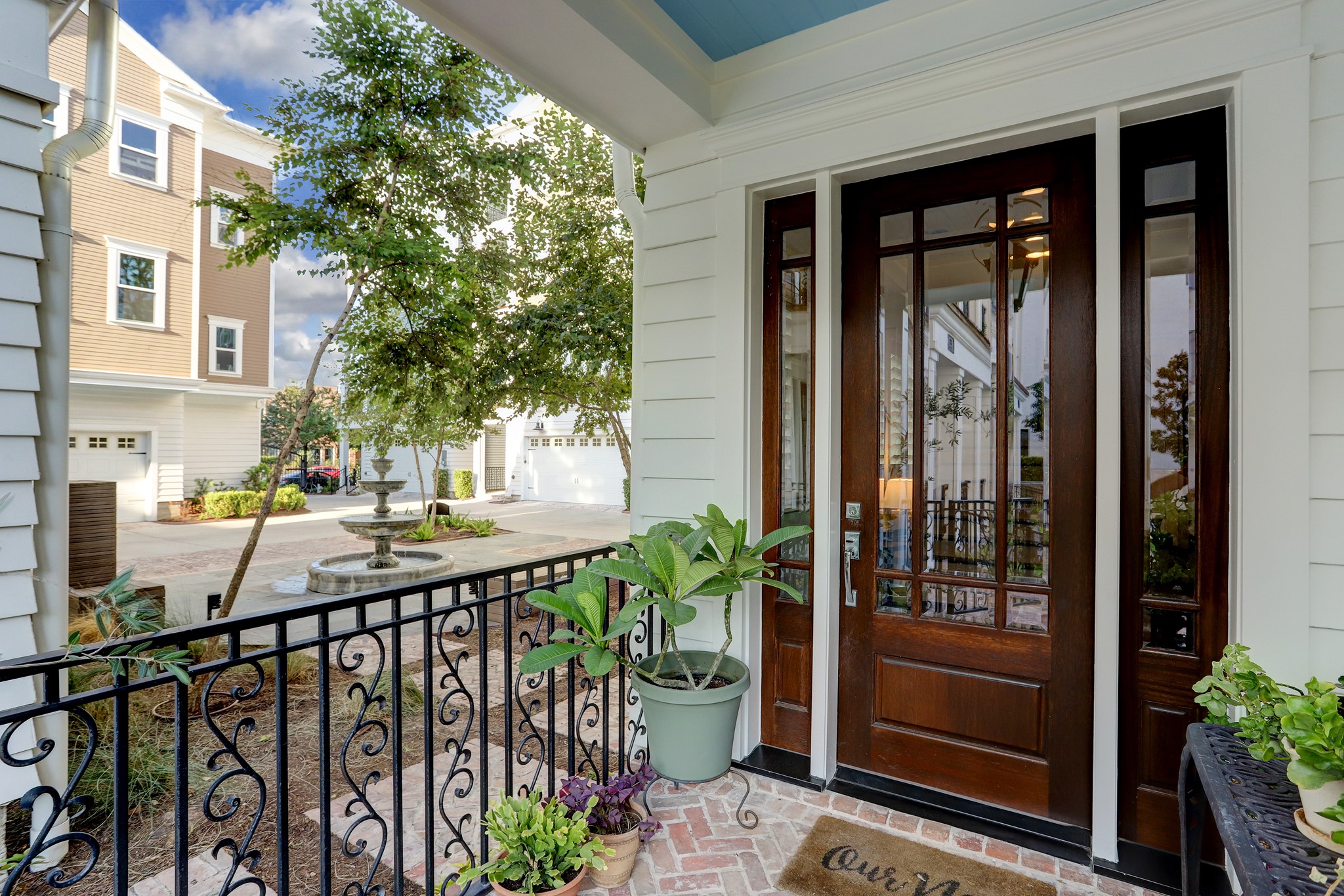 As you walk up to the handsome hardwood front door, you'll hear the trickling fountain where you'll find additional parking and community mailboxes. Shall we go inside?