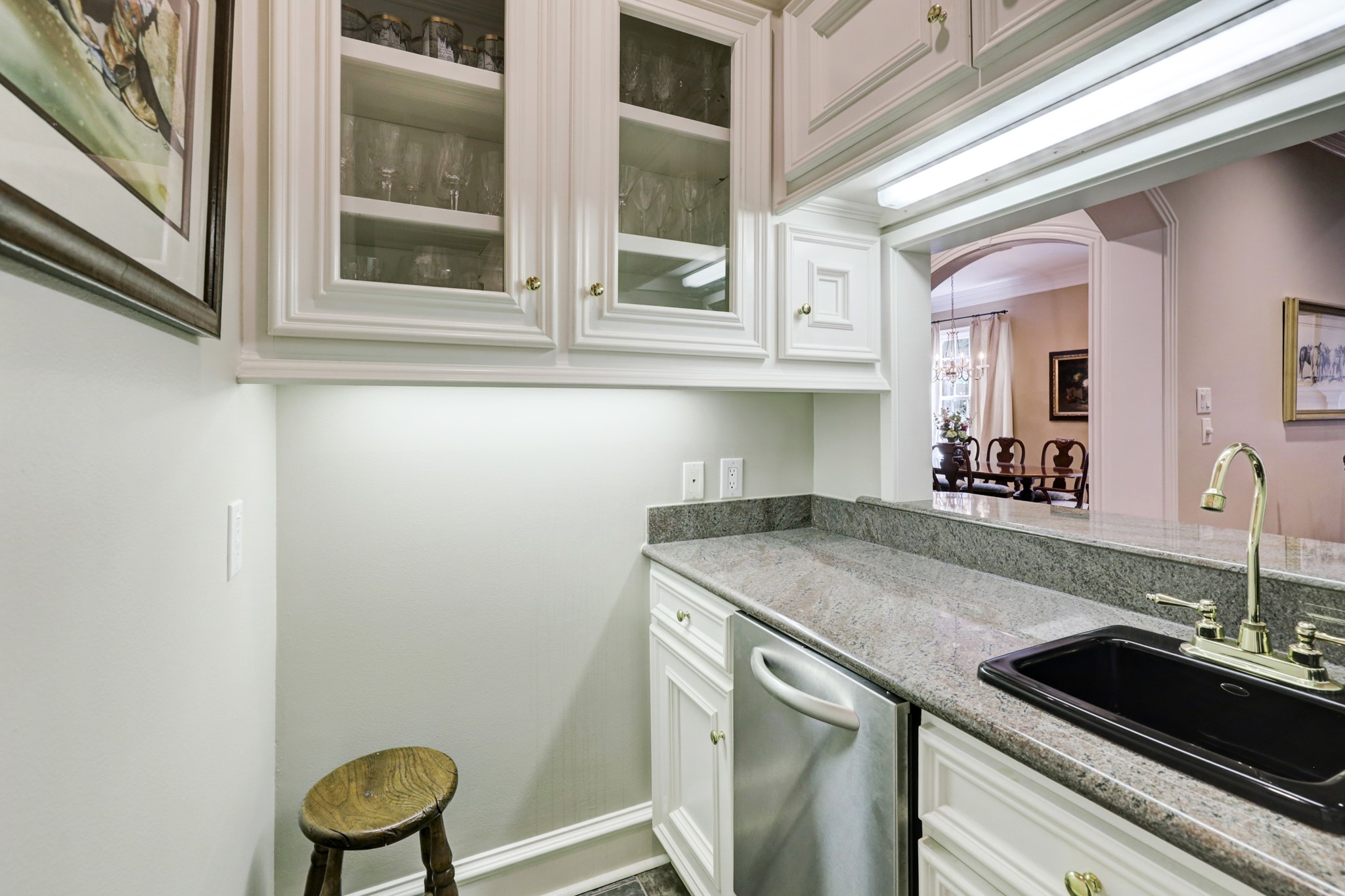 A fabulous wet bar is thoughtfully located off of the Kitchen and steps away from the Family Room. This space features a KitchenAid ice maker, bar sink with brass finishes, glass front display cabinets and extra storage for all of your bar items.
