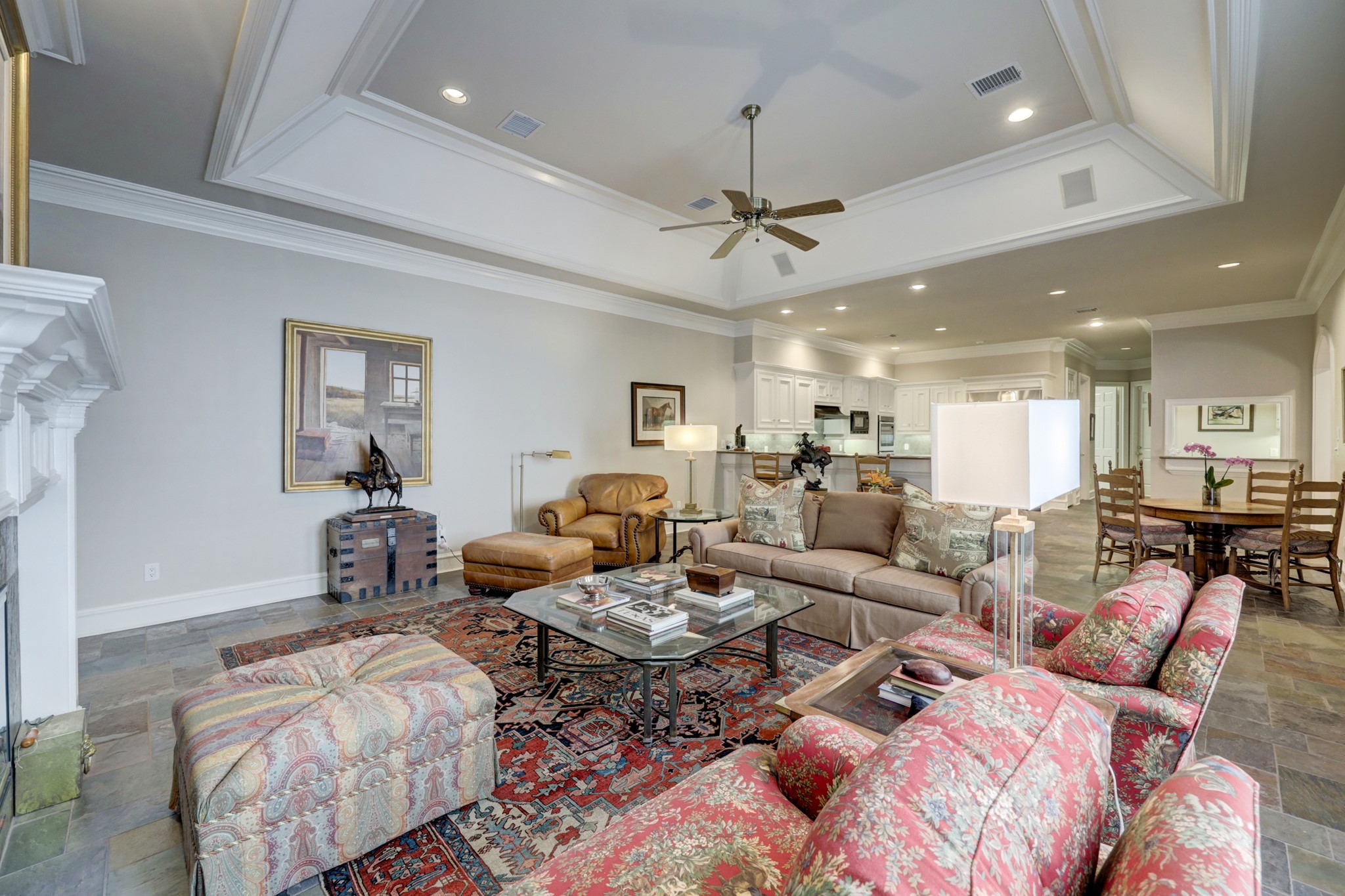 Expansive owner’s suite is located on the second floor through a double door entry and features hardwood floors, soaring vaulted ceiling, gas log fireplace, custom mantle, and bespoke built-ins.
