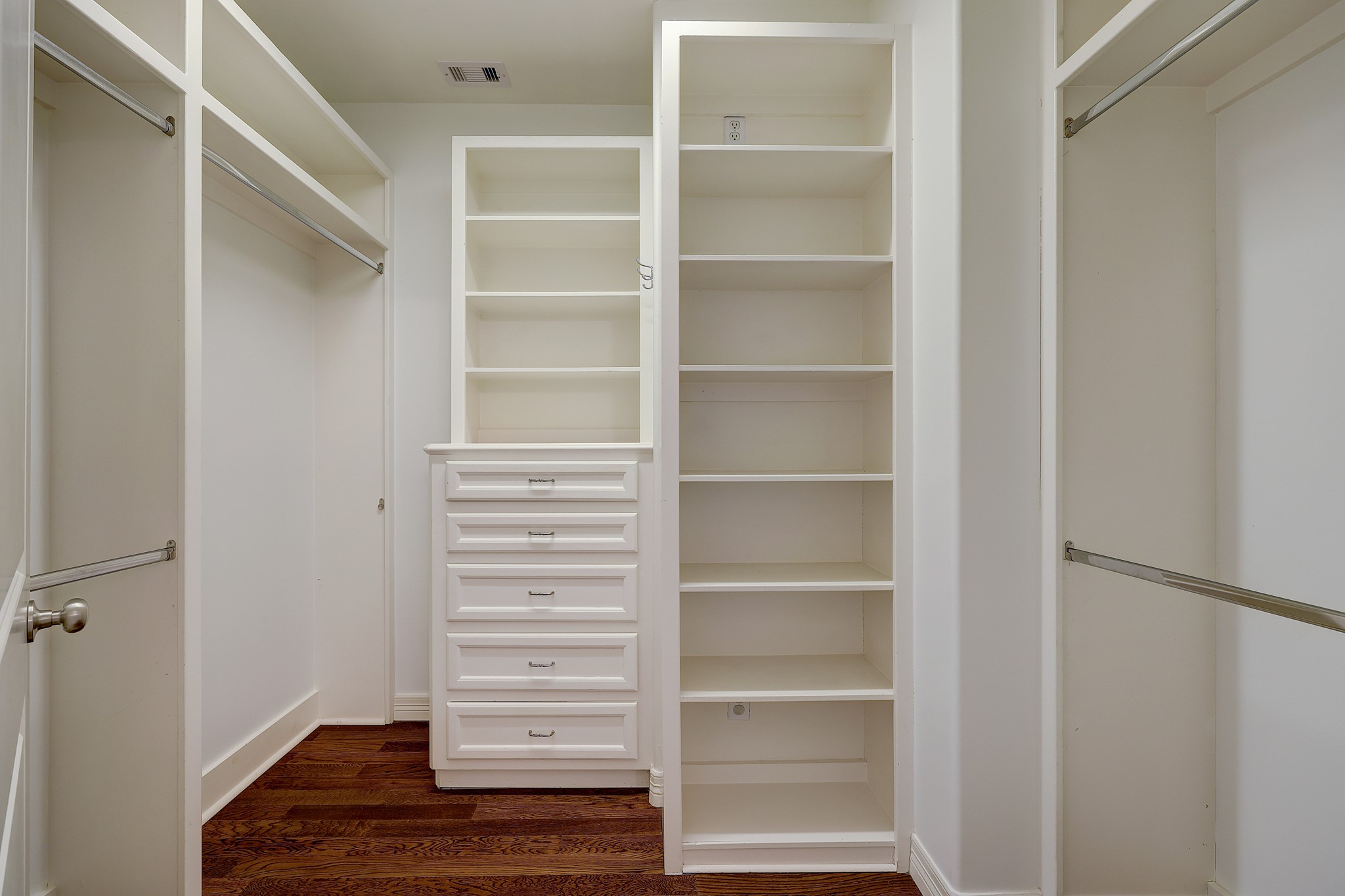 Explore the ample storage possibilities in the second walk-in closet of the owner's suite where space and organization are in abundance. This closet offers extensive shelving, hanging rods, and a built-in chest of drawers, ensuring that every piece of attire and accessory has a dedicated spot. With a smart layout and practical design, this closet is a testament to the thoughtful details that make this home stand out.