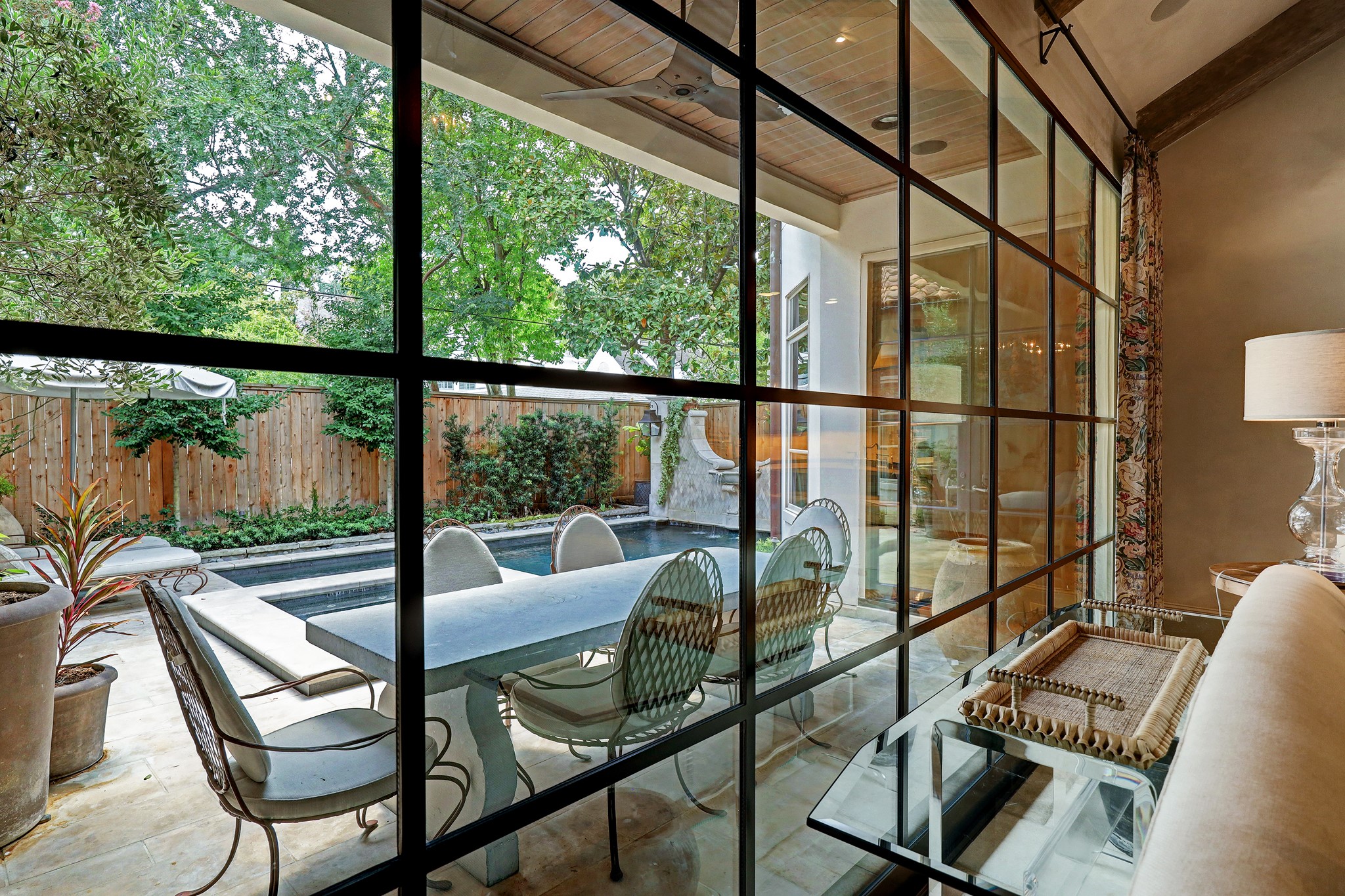 A sweeping wall of floor-to-ceiling steel framed windows provides an exceptional view of the verdant backyard blurring the lines between interior comfort and the natural allure of the exterior oasis.
