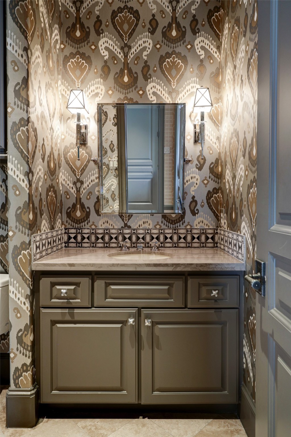 An elegantly appointed powder bathroom, though compact, boasts high-end fixtures and finishes, echoing the luxury of the adjoining spaces. Its strategic placement ensures that guests need not venture far, providing convenience especially during gatherings in the home office or movie marathons in the media room.