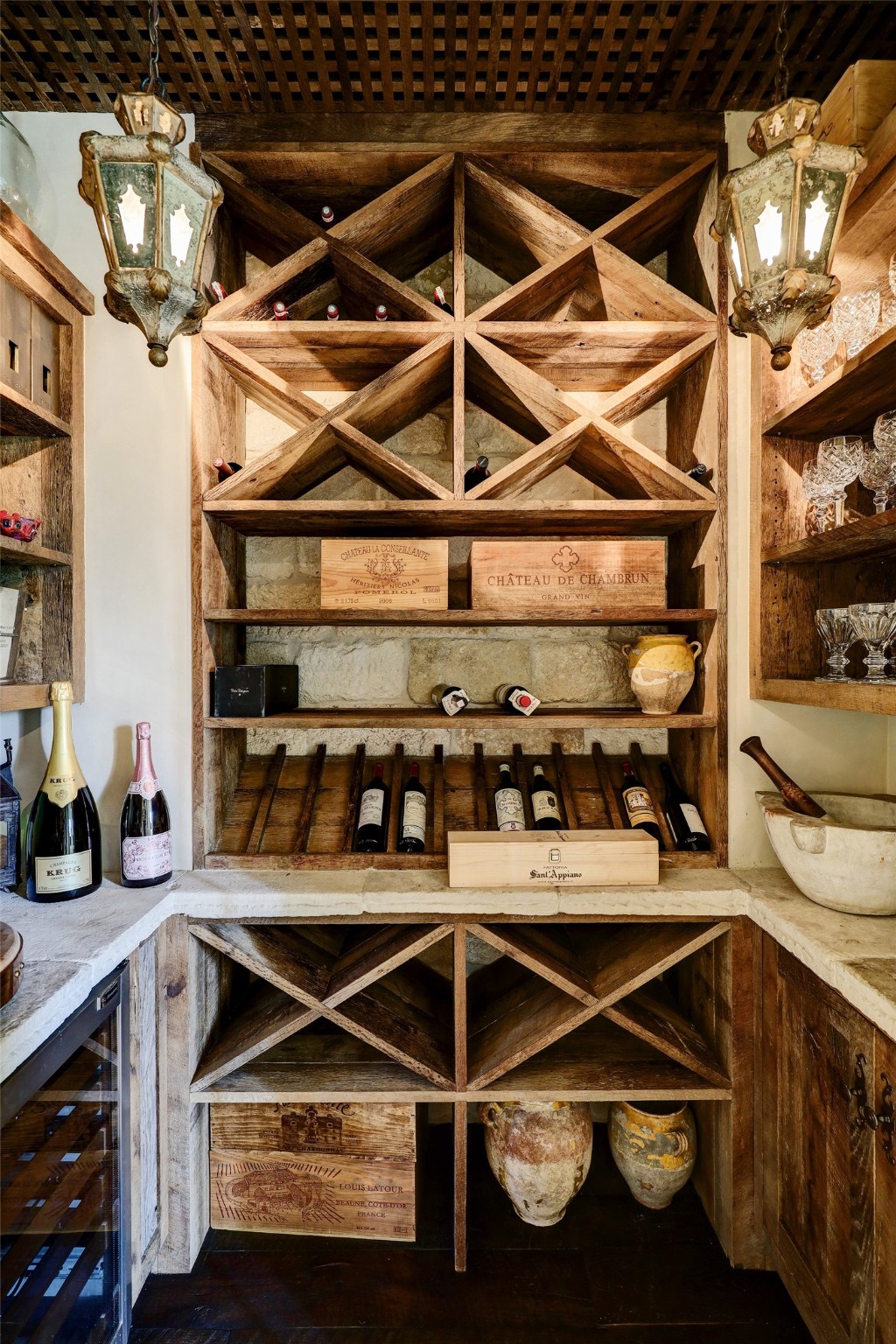 The wine room is a journey back in time with 18th-century lanterns and antique reclaimed stone from Chateau Domingue.