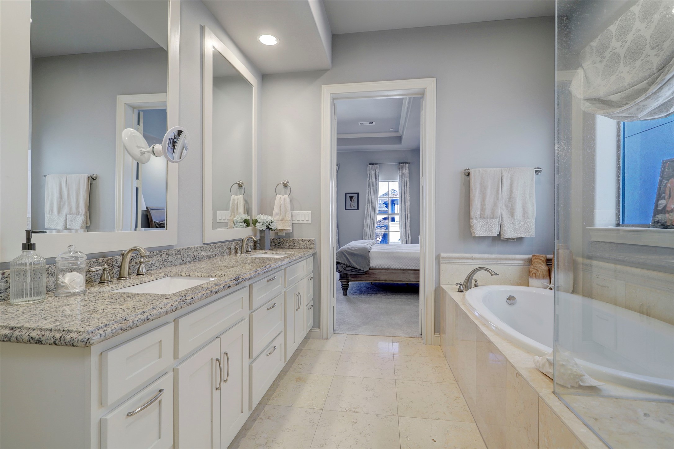 Primary bathroom with natural light , double sinks, soaking tub, separate shower, and bountiful storage.
