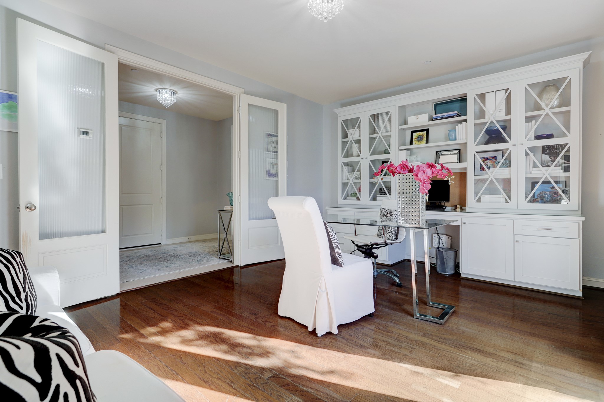 Currently utilized as a home office, double doors allow this space to be closed off for privacy. Custom built-ins add storage, display space, function and interest to the room.