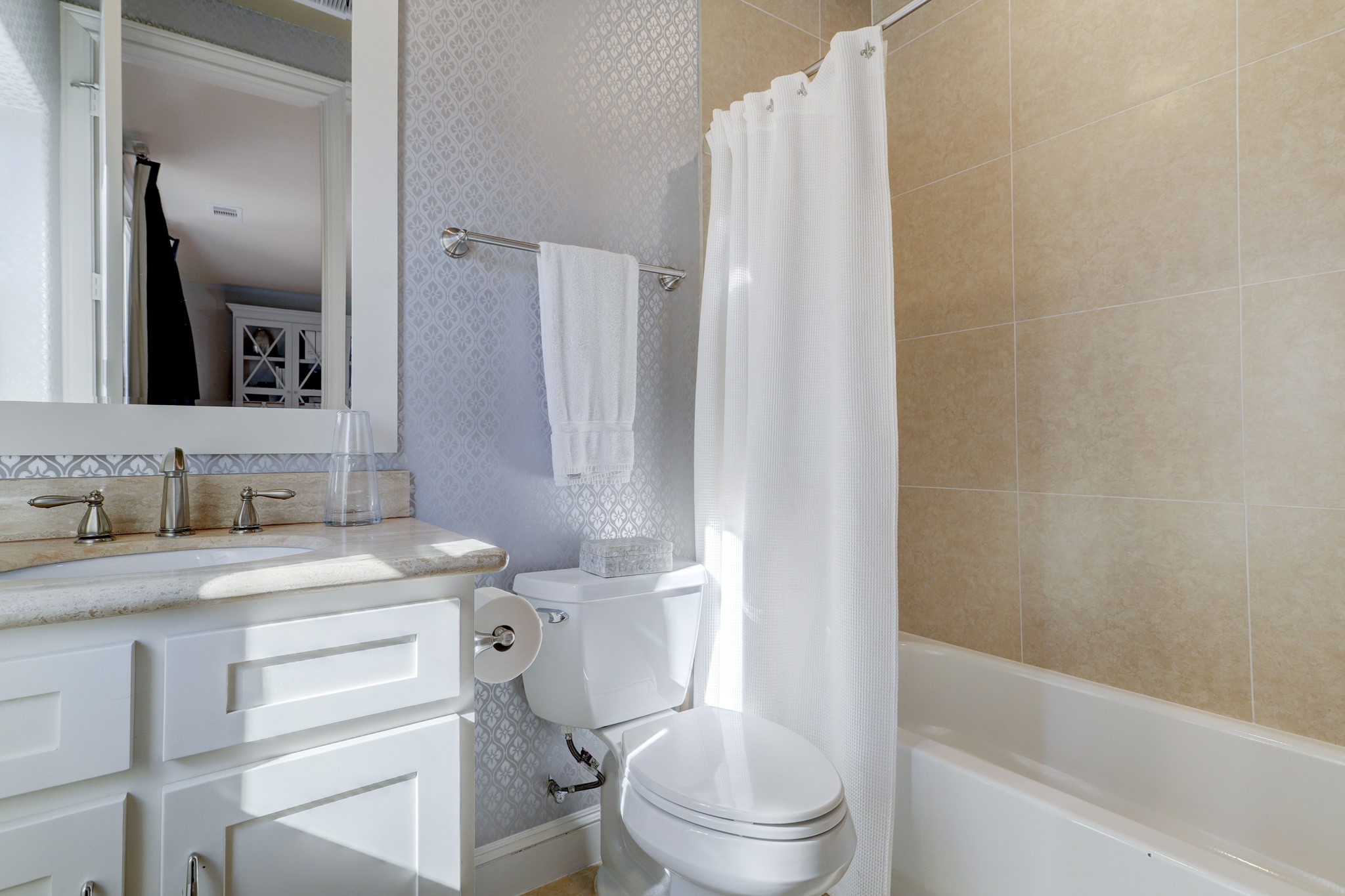 First floor en-suite bath with designer wallpaper, tub/shower combo.