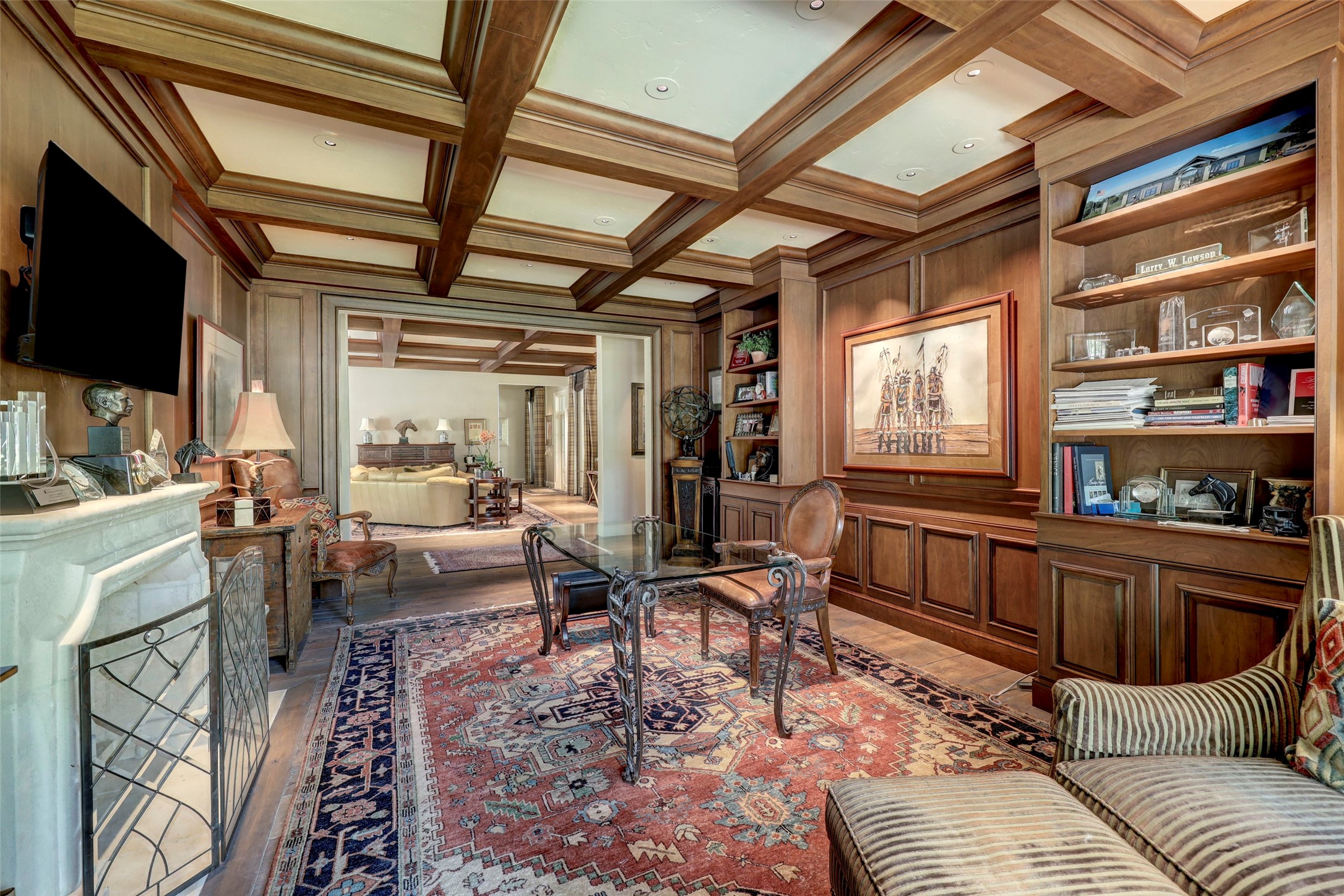 The study includes stone fireplace, beamed ceiling, and stunning cabinetry.