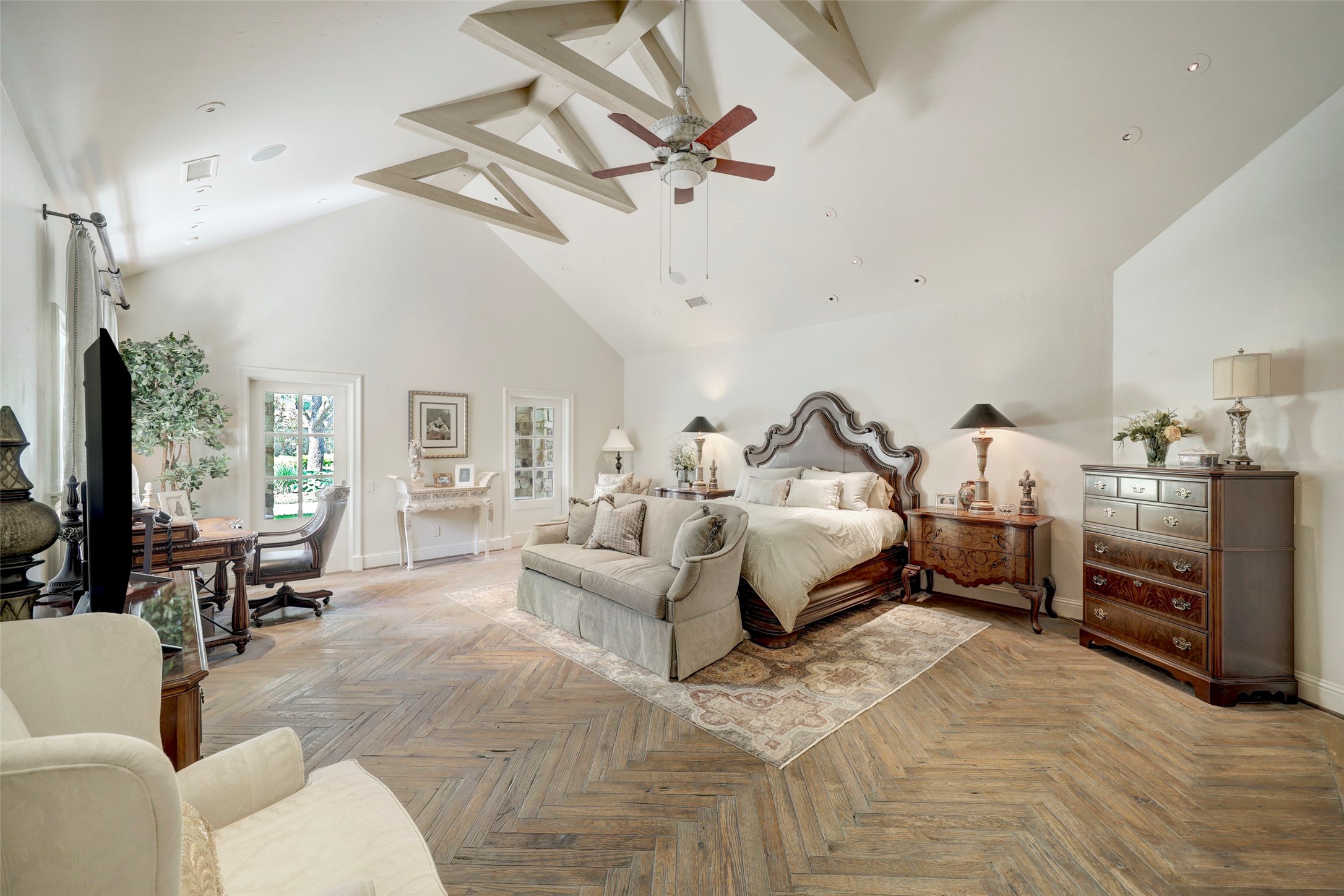 The primary bedroom is a retreat with vaulted beamed ceiling, stunning wood floor and access to the resort backyard.
