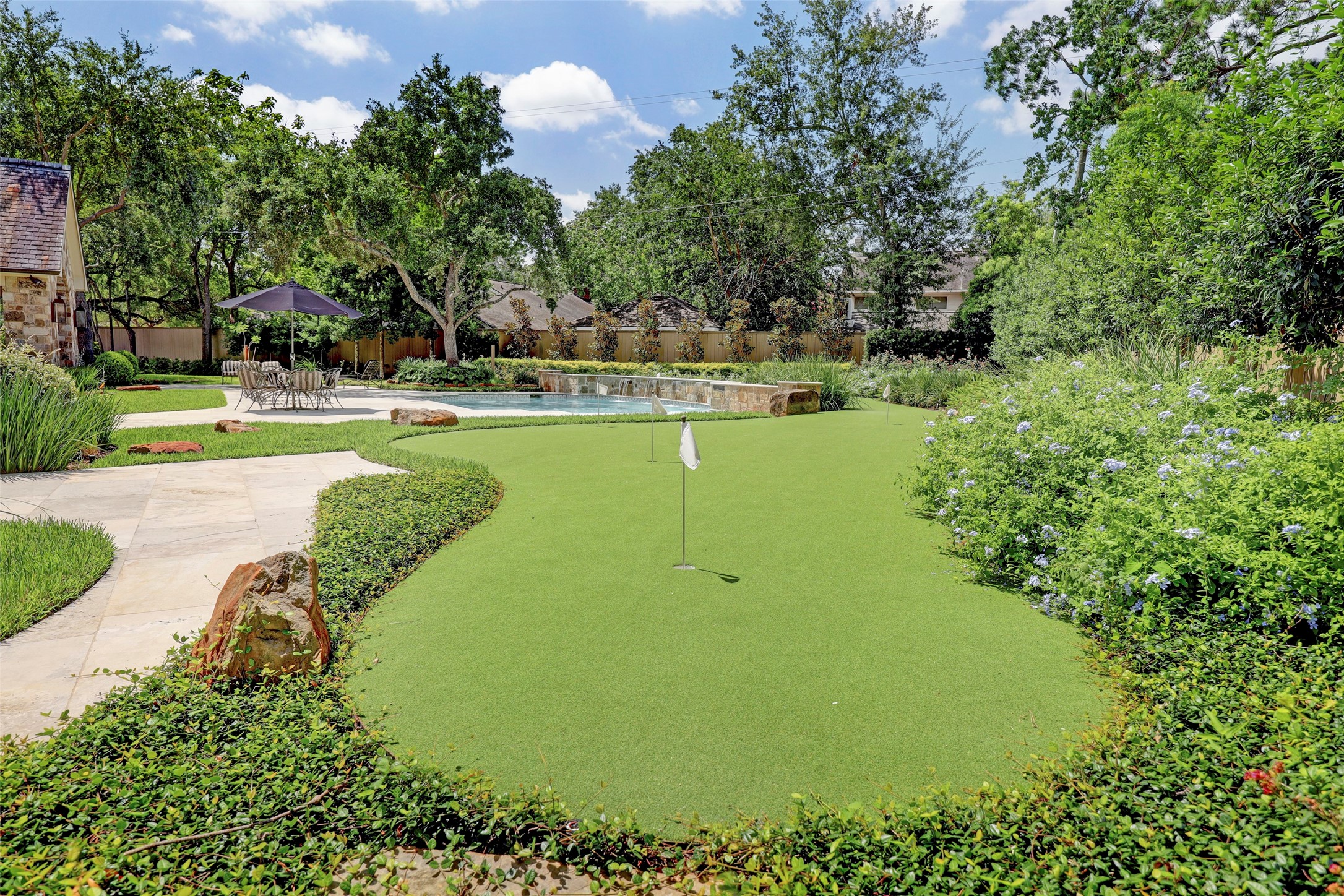 Large putting green that wraps around the back of the pool complete with sand trap.