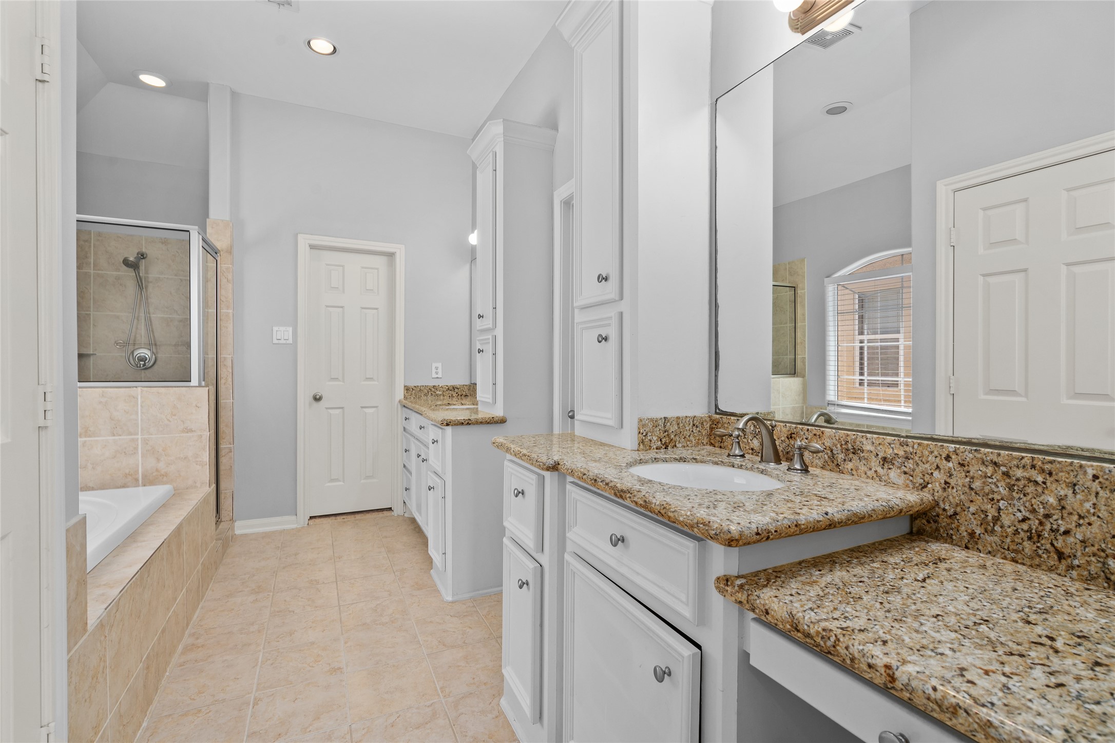 The primary bath room features dual vanities, jetted tub, separate shower, water closet and ample storage.