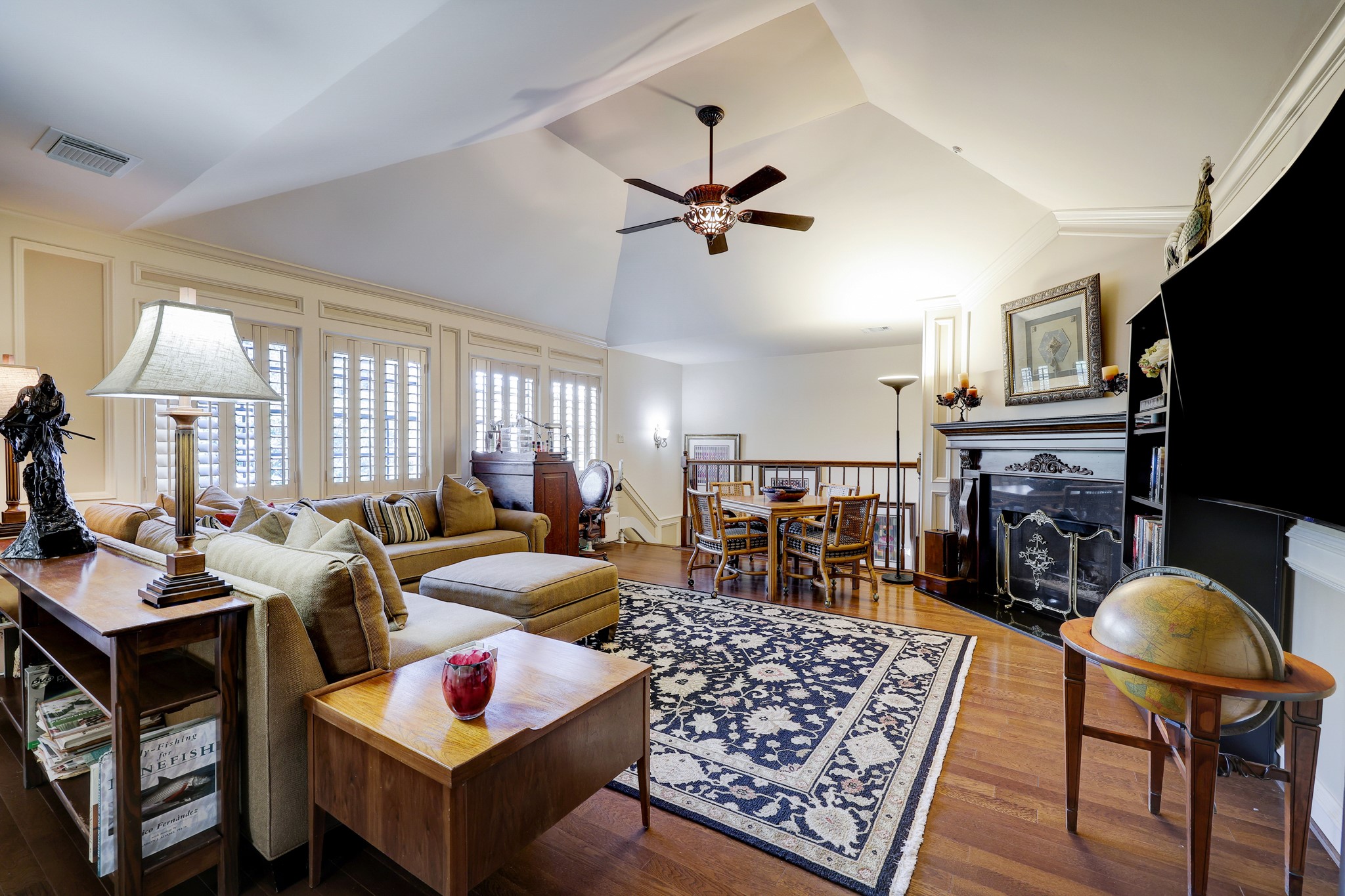 The spacious great room on the second floor features plantation shutters that offer both privacy and a timeless aesthetic. A custom mantel makes this area an ideal retreat for relaxation or entertainment. The vaulted ceilings amplify the sense of space, creating an open, airy atmosphere.