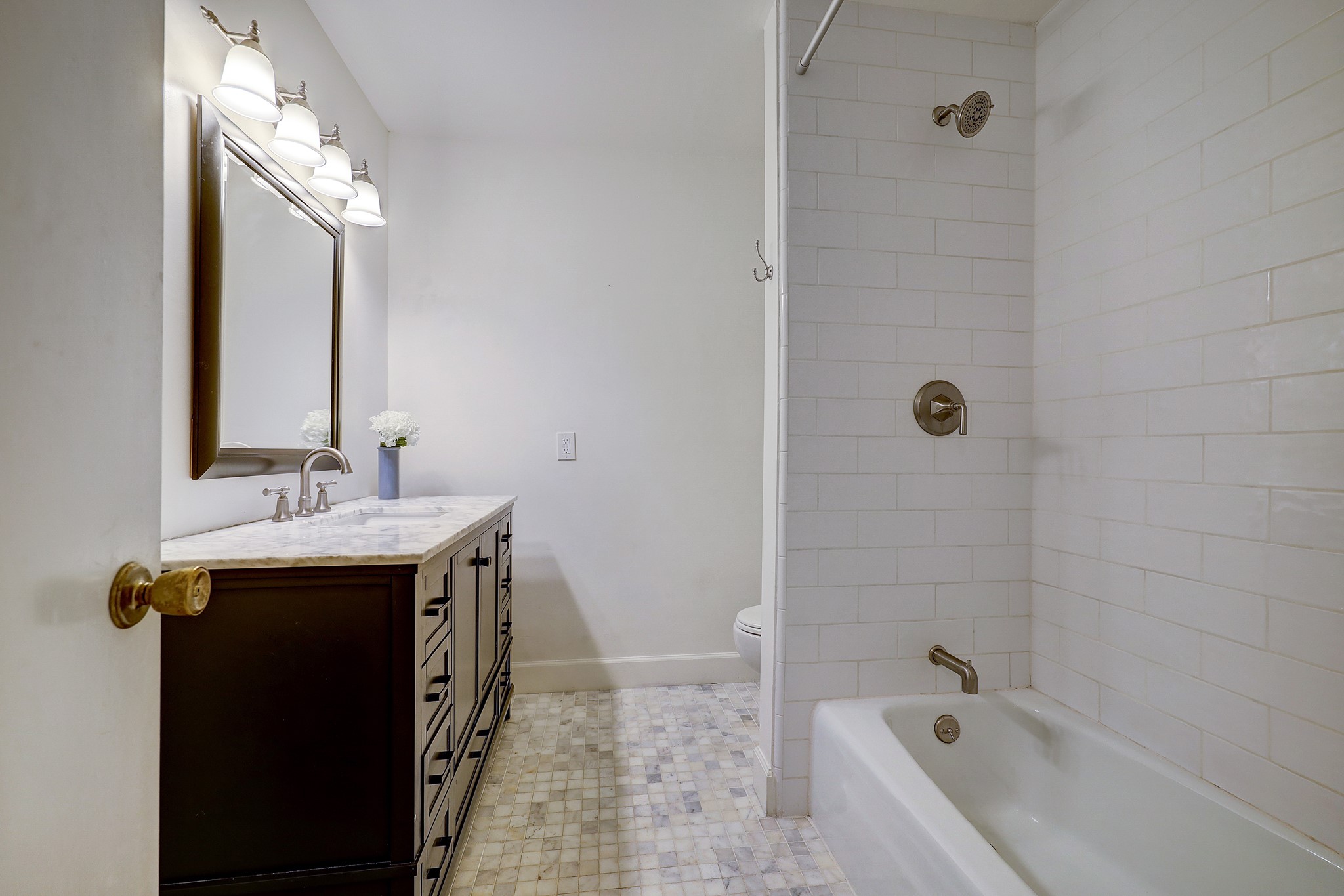 Recently updated secondary bathroom with marble countertops and a tub/shower combo. There is also a powder bath on first floor. *As per seller.