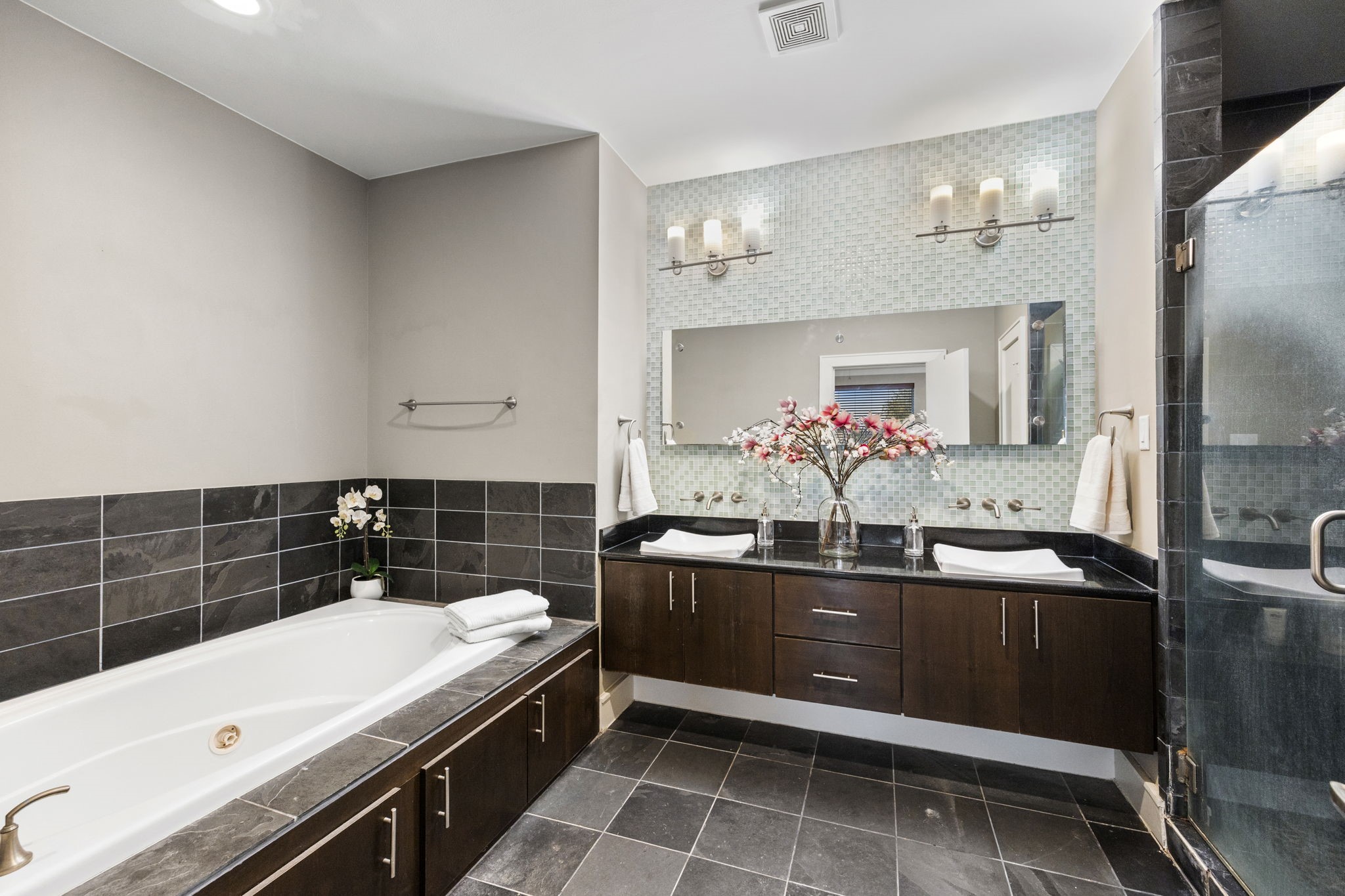 The Ensuite Primary Bath has Granite Countertops, Custom vanity featuring Dual Sinks, an Oversized Jetted Tub, and Tile Flooring! 322 Patterson St., Houston, TX  77007