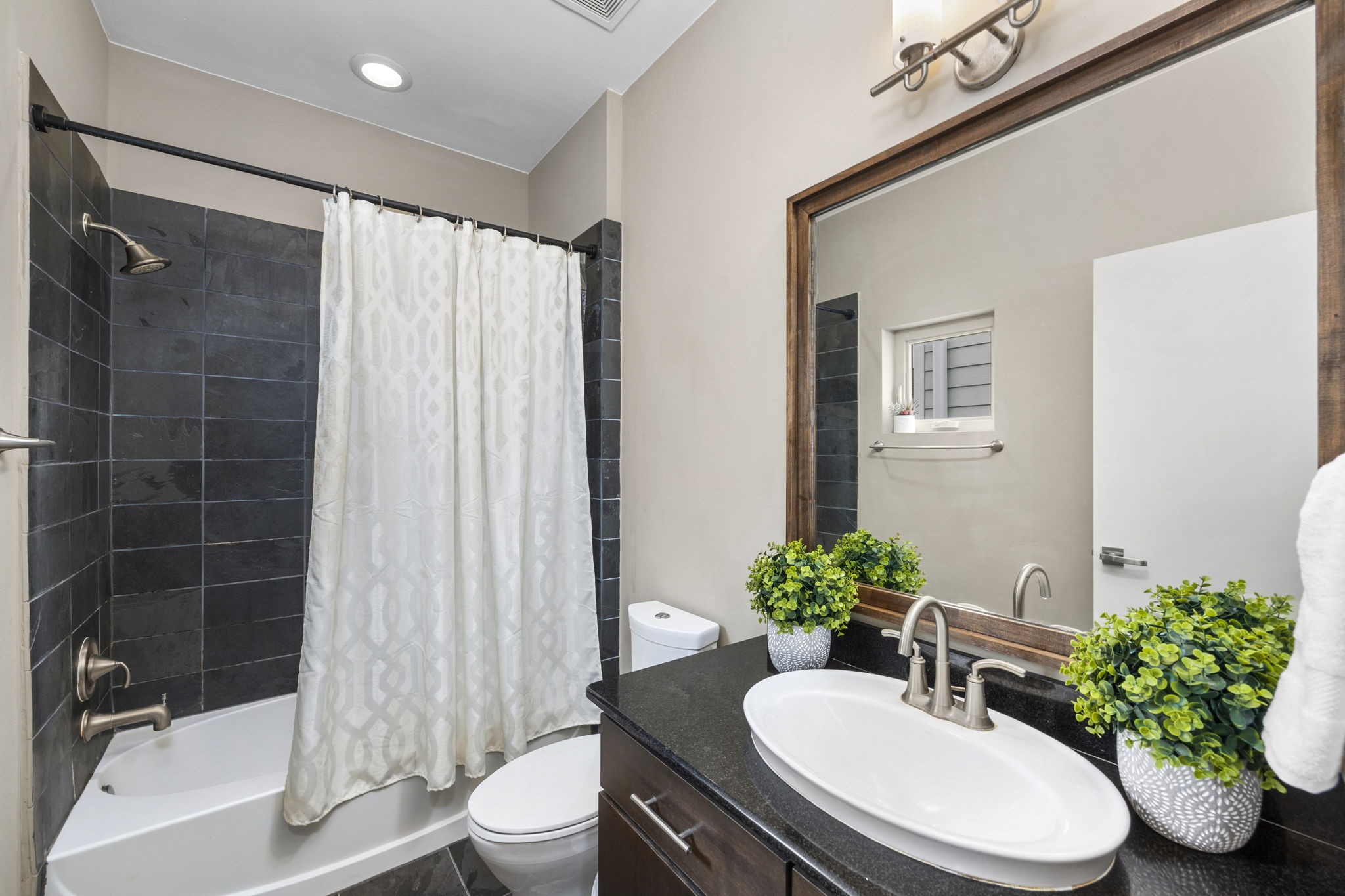 Full sized bathroom featuring a tub/shower combo ensuite for the secondary bedroom located on the 3rd floor. 322 Patterson St., Houston, TX  77007