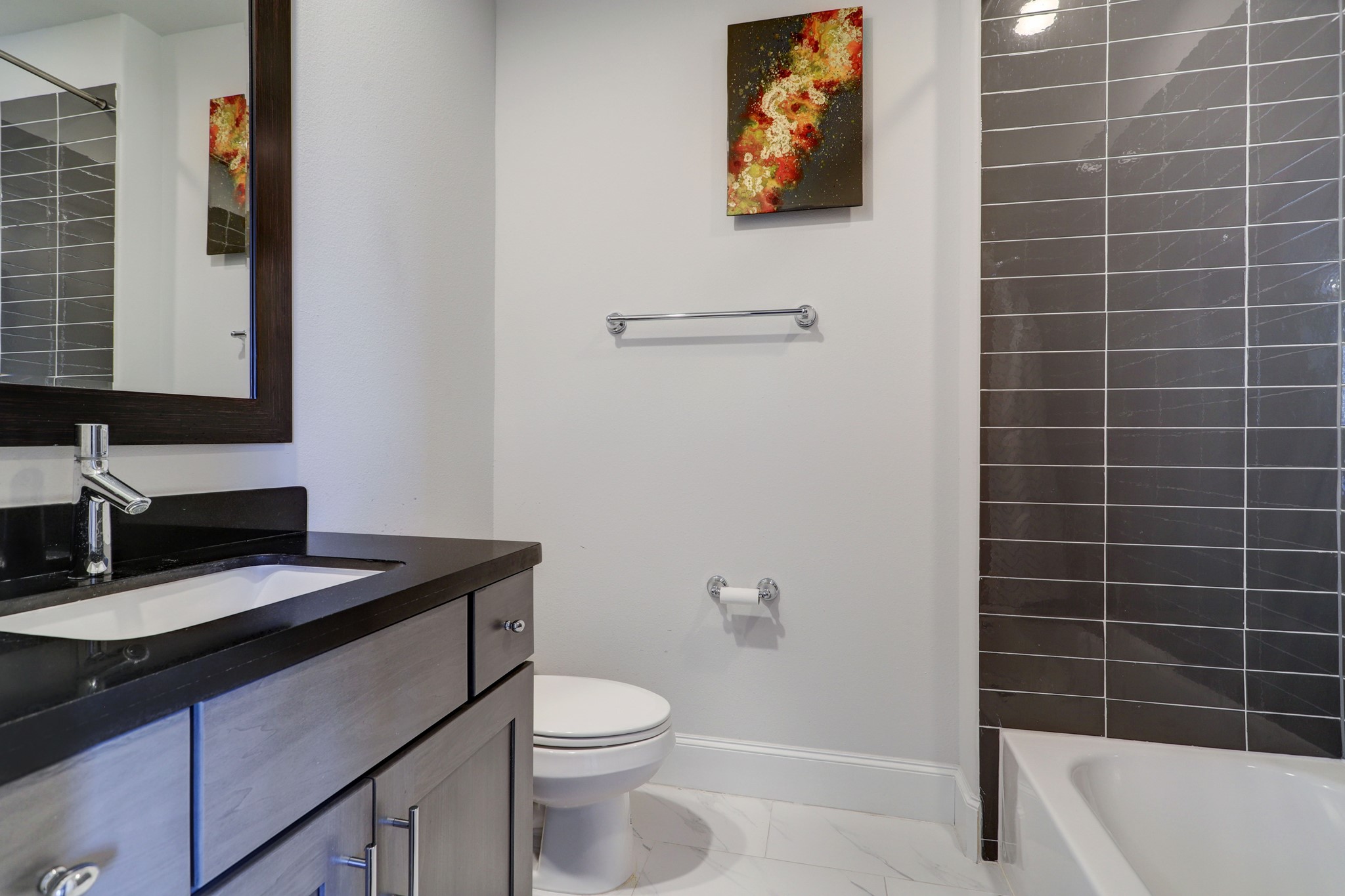 Attached full bathroom on the first floor has a combo shower/tub with sleek tile surround.