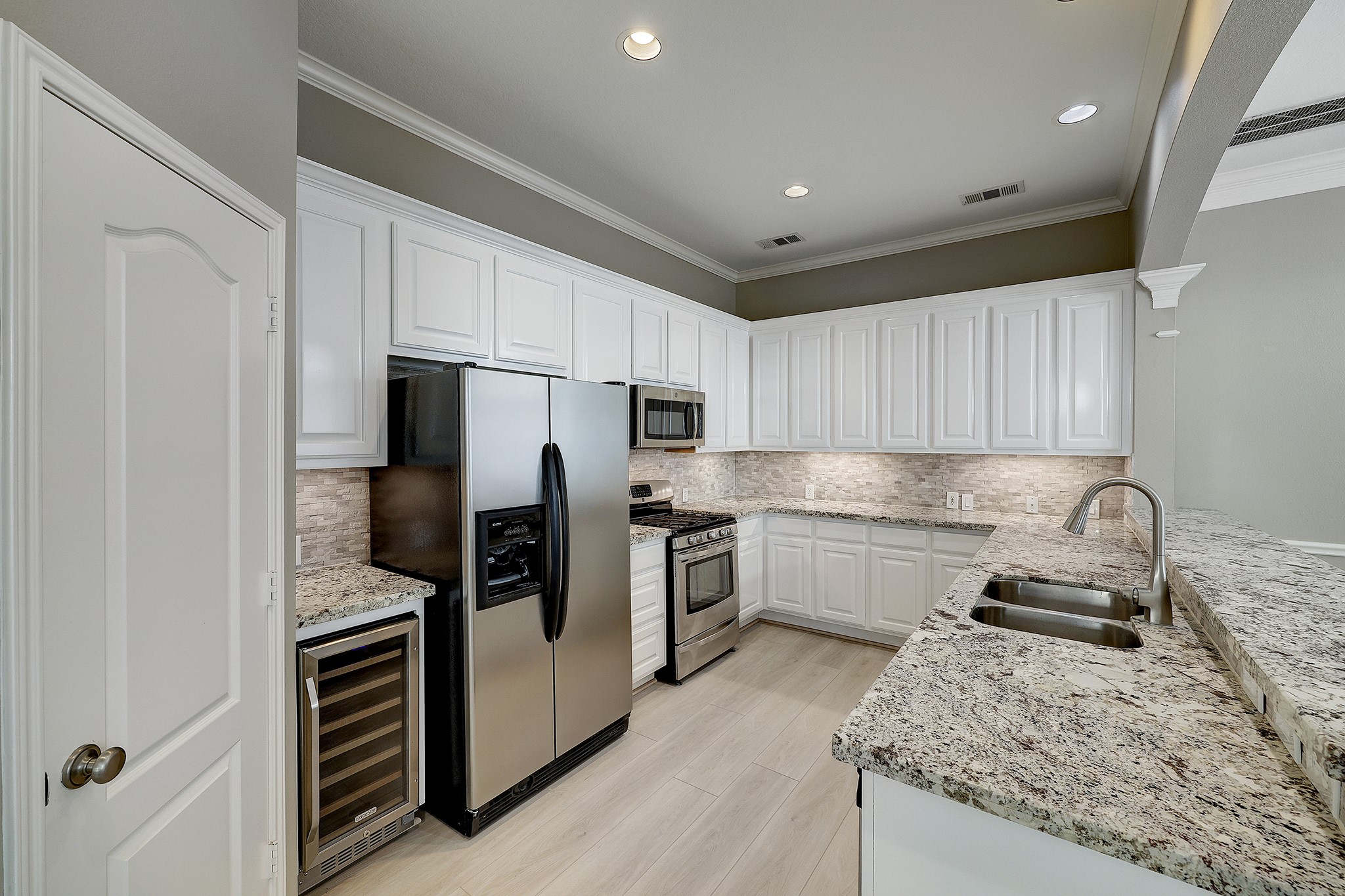 Elegant granite countertops, abundant storage and wine fridge adorn the open kitchen. Refrigerator included