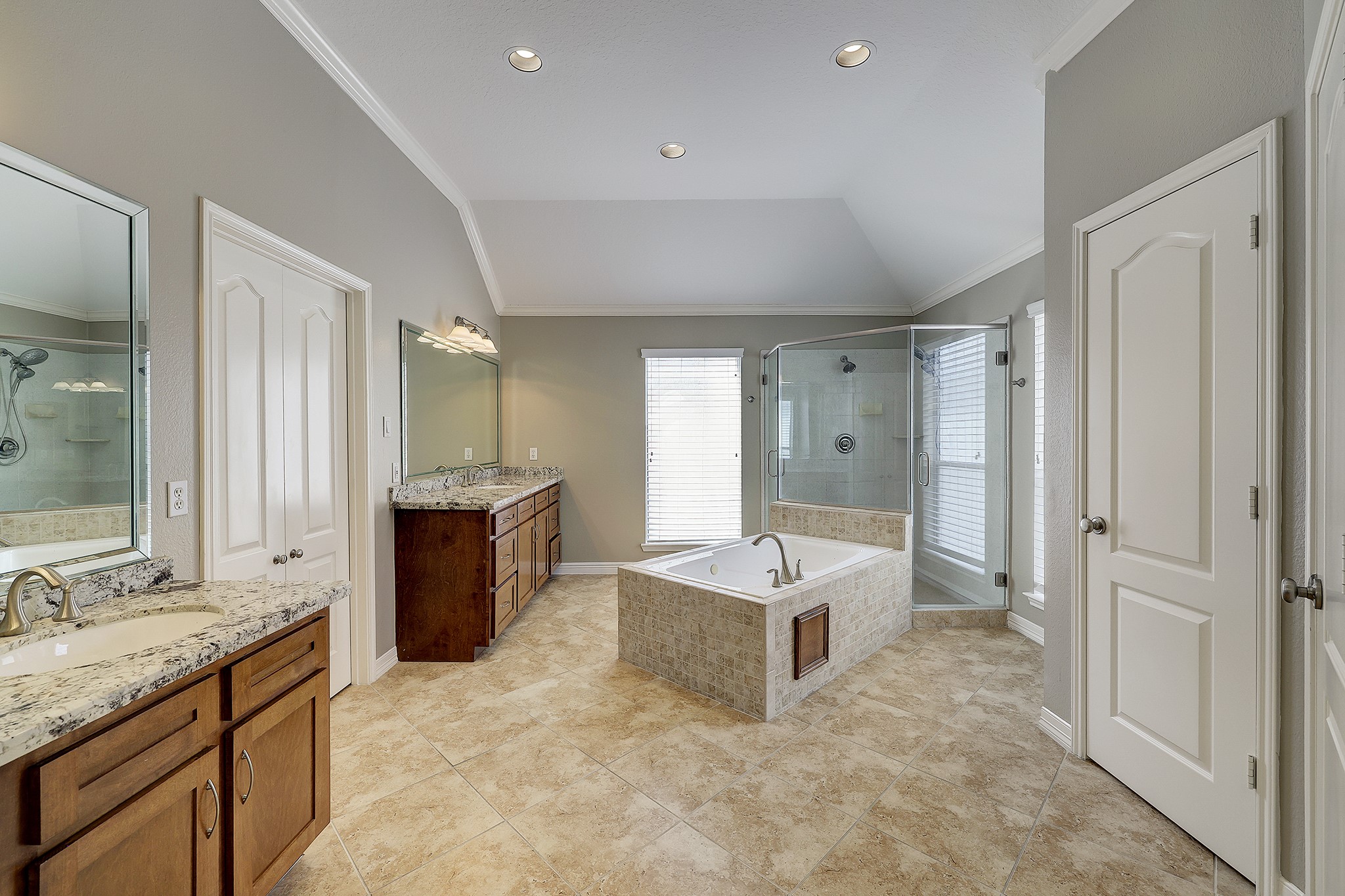 Spacious primary bathroom featuring a generous walk-in shower, jetted tub, and a private enclosed commode