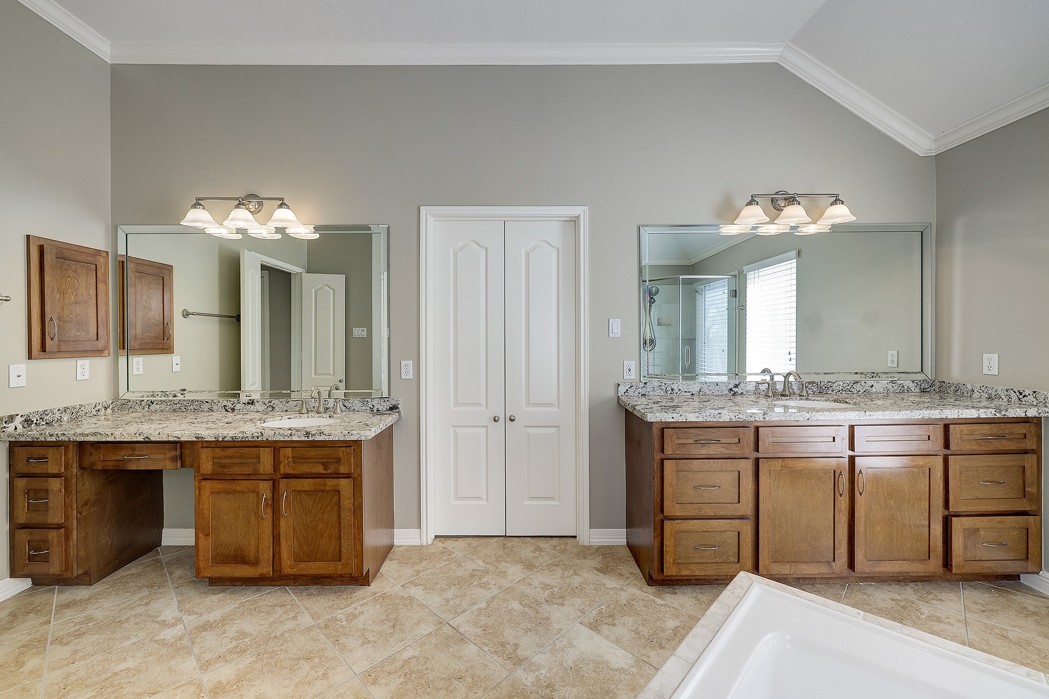 Primary bathroom with double sinks, ample cabinet space, and a charming vanity nook