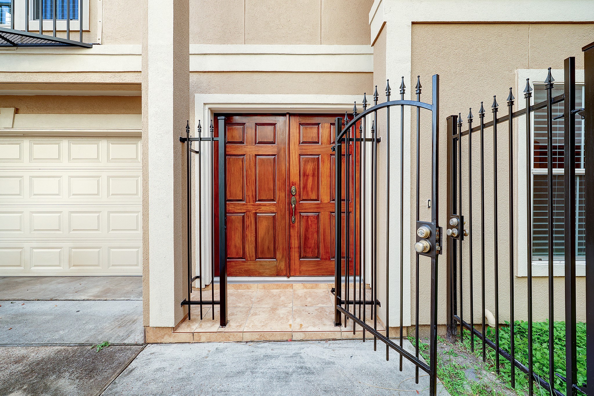 Stately double door front entry with an additional gate for added security