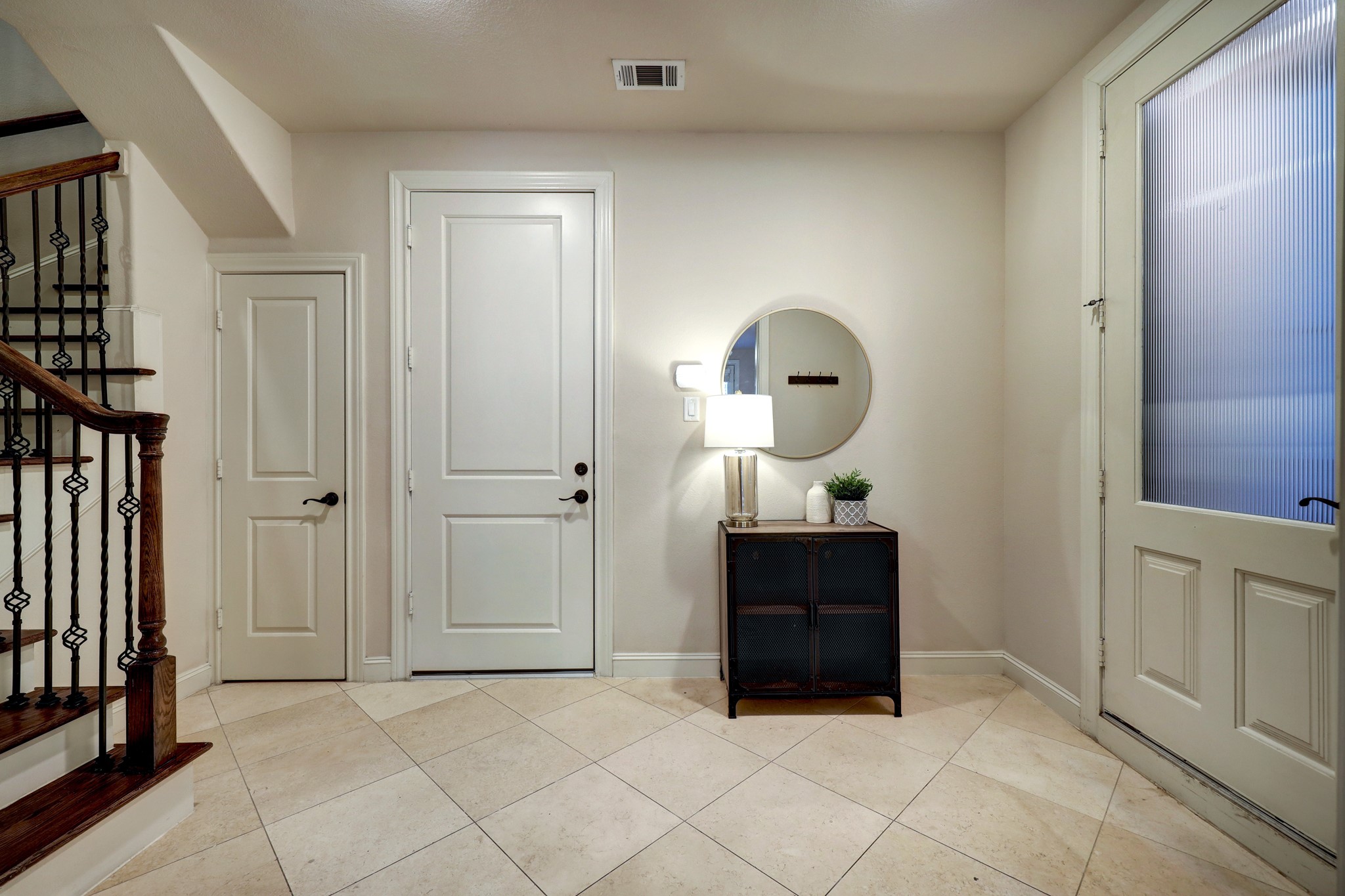 This welcoming entryway offers lovely travertine floors, a large storage closet, convenient garage access, and access to beautiful bedroom with private deck.