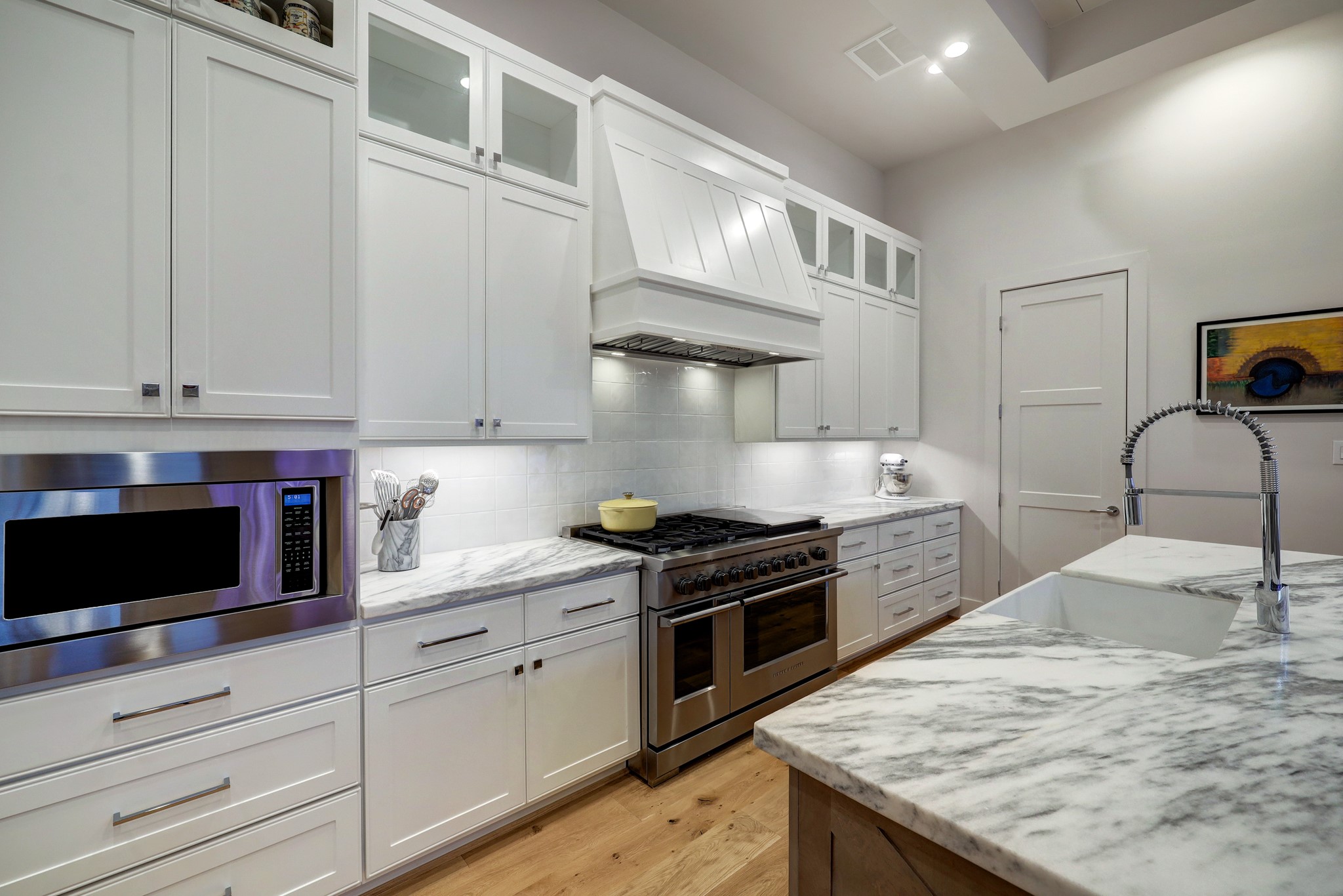 Chefs will love this exquisite gourmet kitchen filled with crisp white custom cabinetry, a large island/breakfast bar and rich marble countertops.