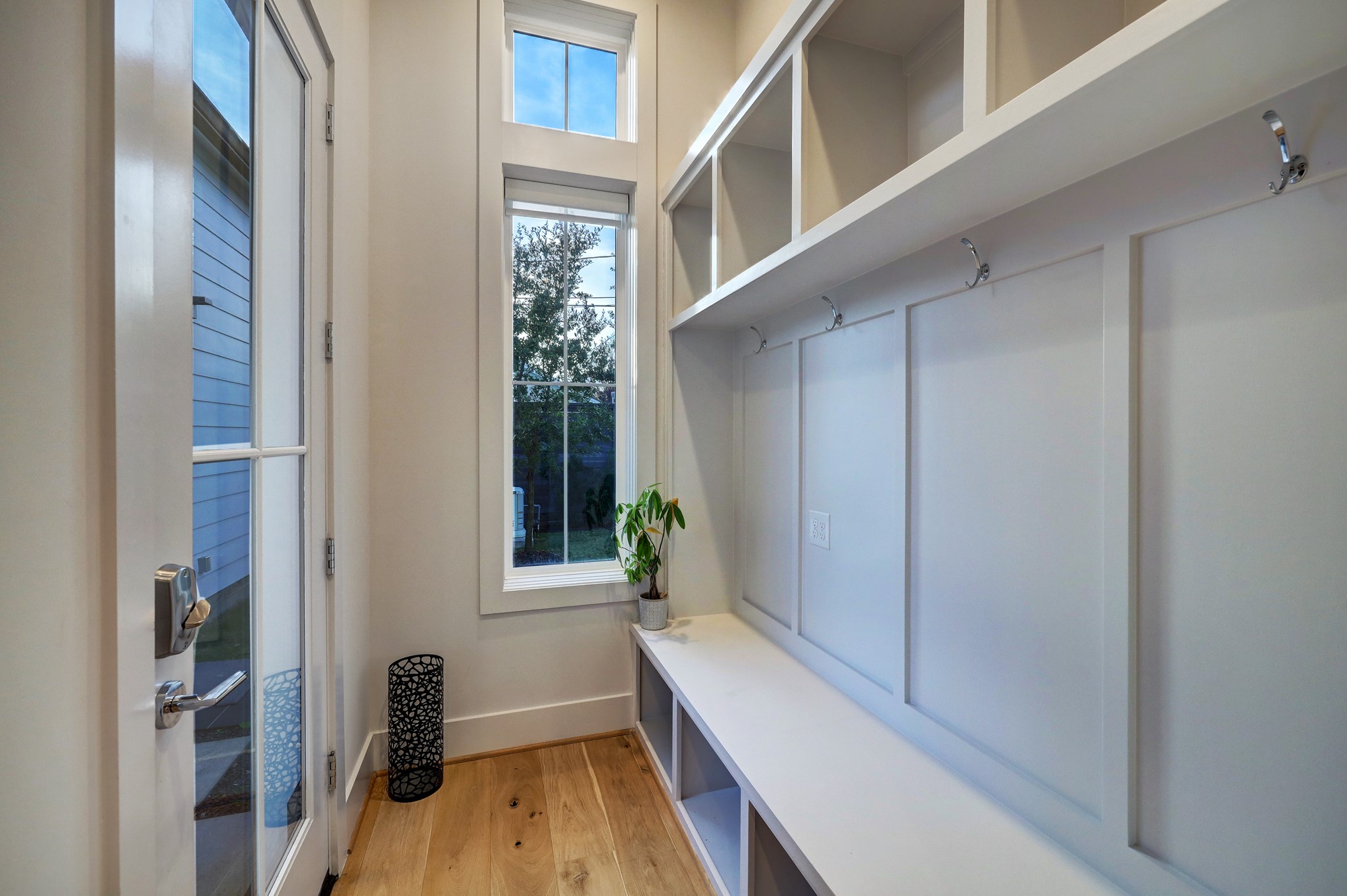 Past the kitchen and living room, a large mudroom with bench seating and cubbies ensures organized arrivals and departures.