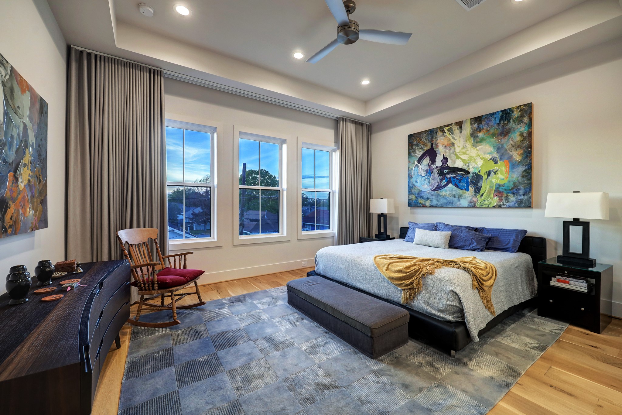Sleep soundly in the expansive owner's suite, where a trio of large windows overlooks the backyard. A tray ceiling with recessed lighting and a ceiling fan rises overhead.
