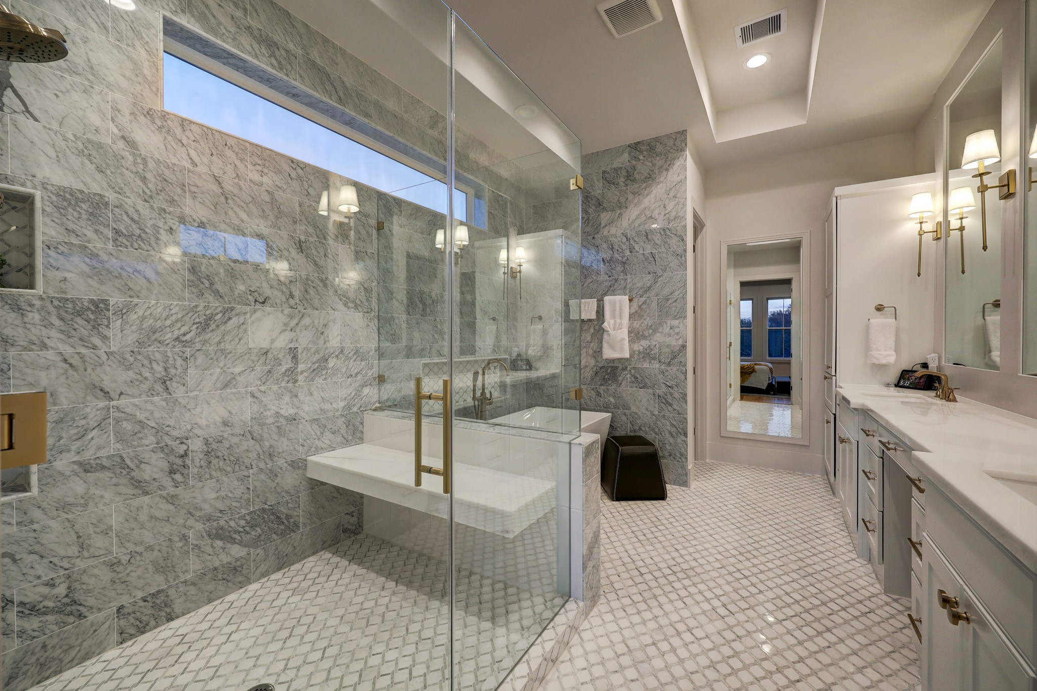 The windowed owner's bathroom dazzles with designer tile, floor-to-ceiling marble and a wide double vanity with great storage and a knee space.