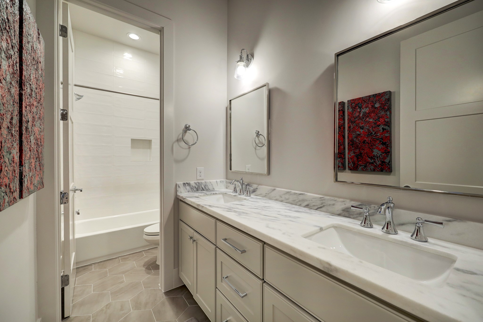 Two secondary bedrooms share this well-appointed hall bathroom with a double vanity area and a separate wet room tub/shower and commode.