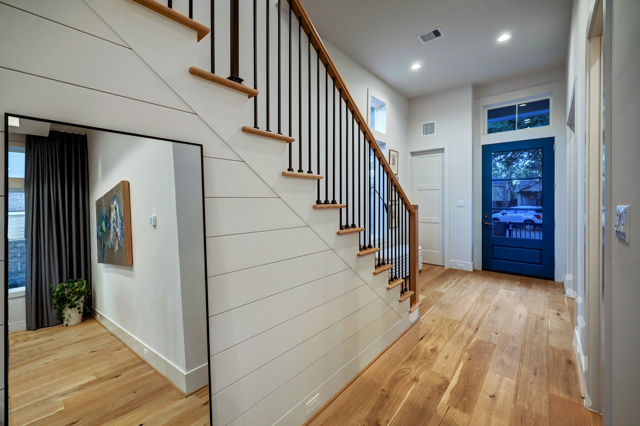 Thoughtful details like an oversized coat closet, transom window and shiplap feature wall add warmth and convenience to this incredibly welcoming home.